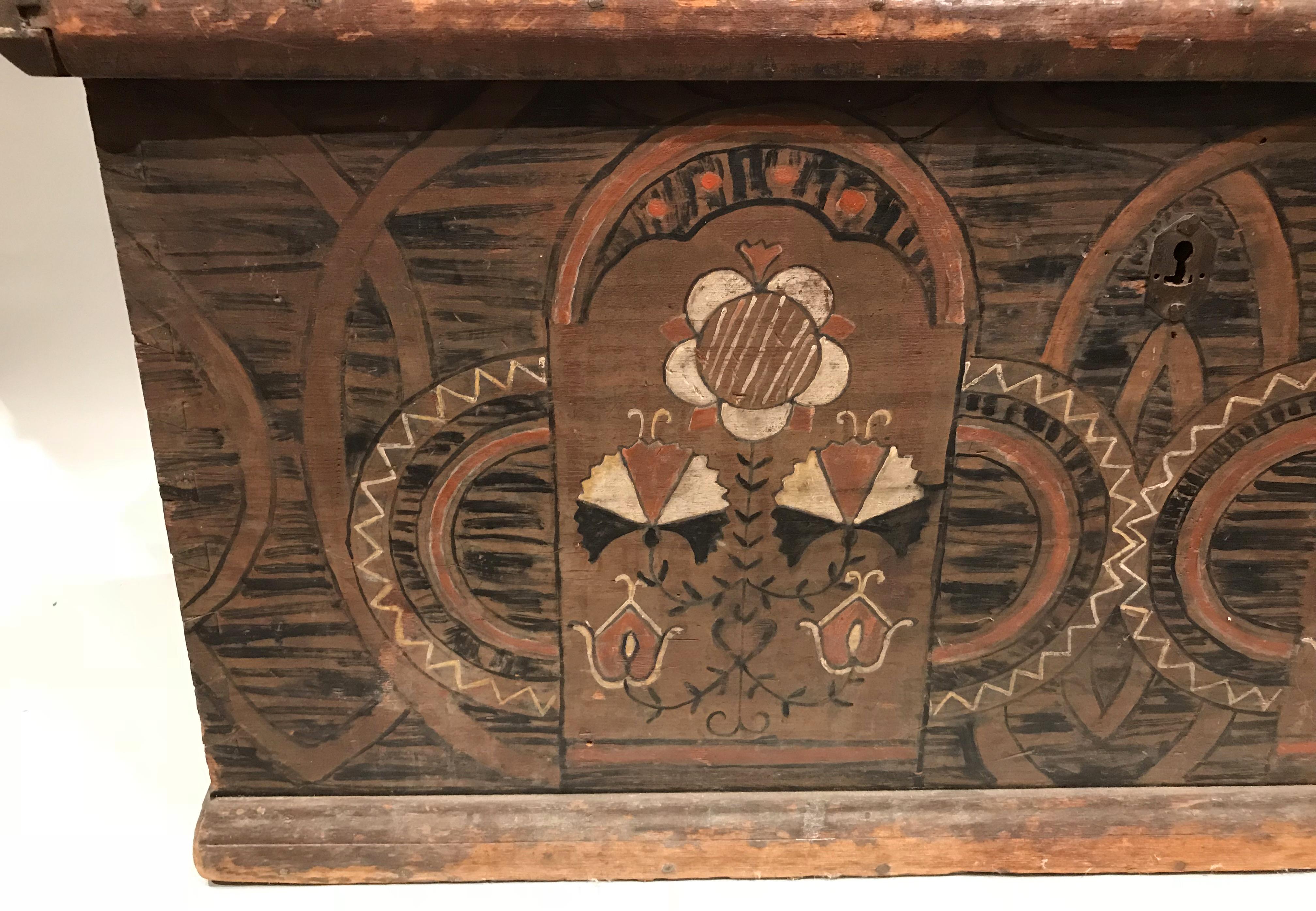 An exceptional polychrome paint decorated tulipwood dower chest with stylized arches in red, black, brownand white, with floral accents and geometric patterns. The decoration is continued on each end and the chest has retained its original