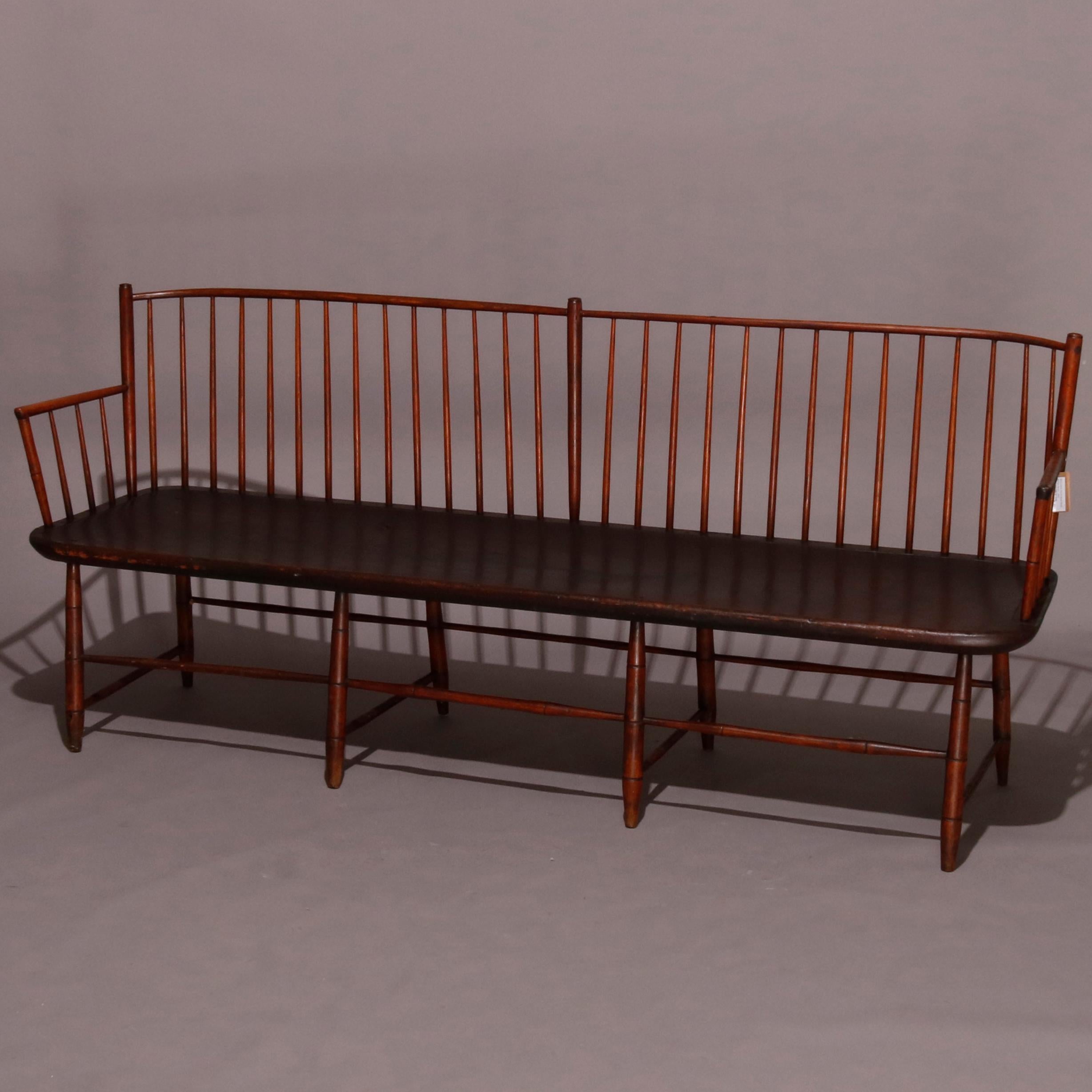 A period Americana Windsor bench features mixed wood construction with plank seat, tapered spindles in a bowed back and raised on eight legs with stretchers, 18th century

Measures: 35