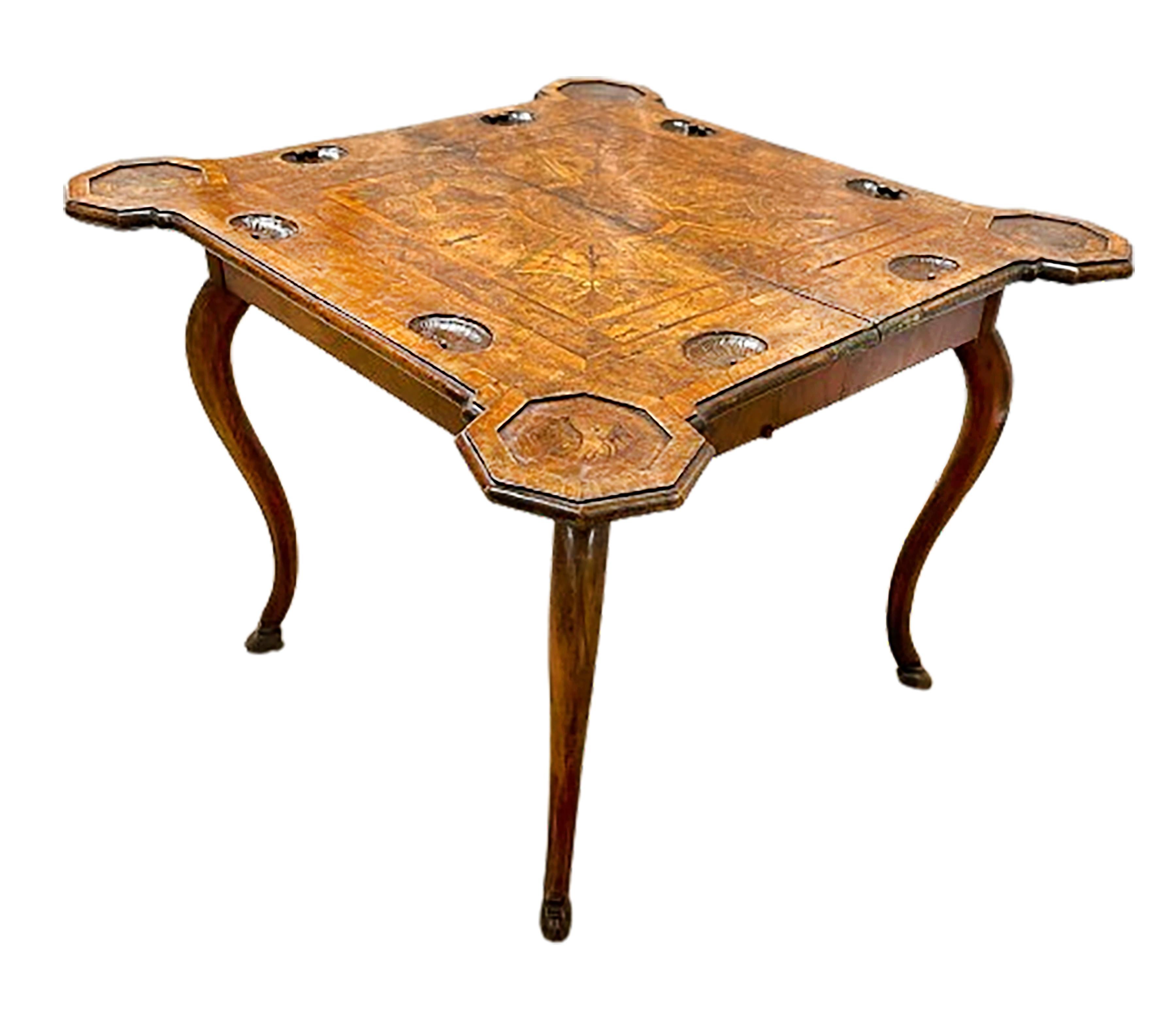 An exquisite 18th century period game table. This stunning game table folds open to reveal dual shell carvings on four sides of the top. Subtle inlaid parquetried and burled pattern trim in the center of the top among a beautifully symmetrical