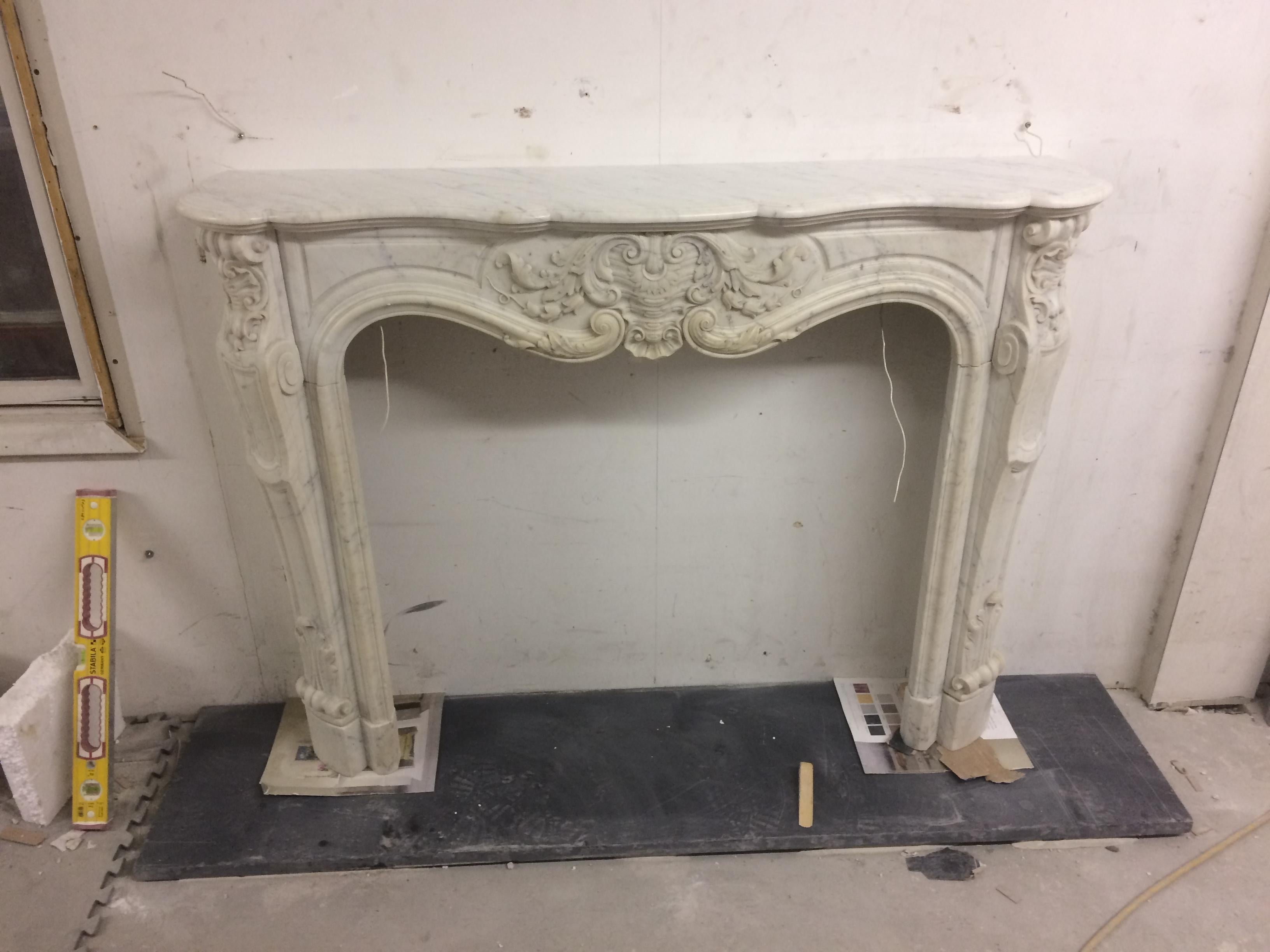 Petite Louis XV style mantelpiece with Scallop shell Cartouche carved in Carrara marbel.

Opening dimensions: 38