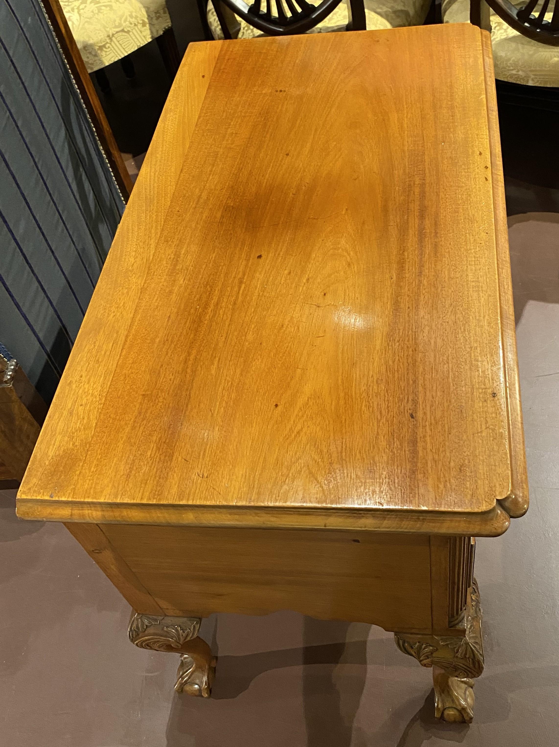 A finely carved Chippendale Walnut Philadelphia lowboy with a rectangular molded edge top with pinched front corners surmounting a case with one frieze drawer over three fitted drawers, the center of which is beautifully shell carved with a detailed