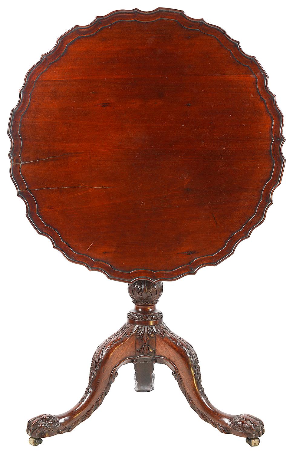 A very good quality Chippendale style mahogany occasional table, having a pie crust top above a ring turned pedestal with carved foliate decoration, tripod supports terminating in ball and claw feet.