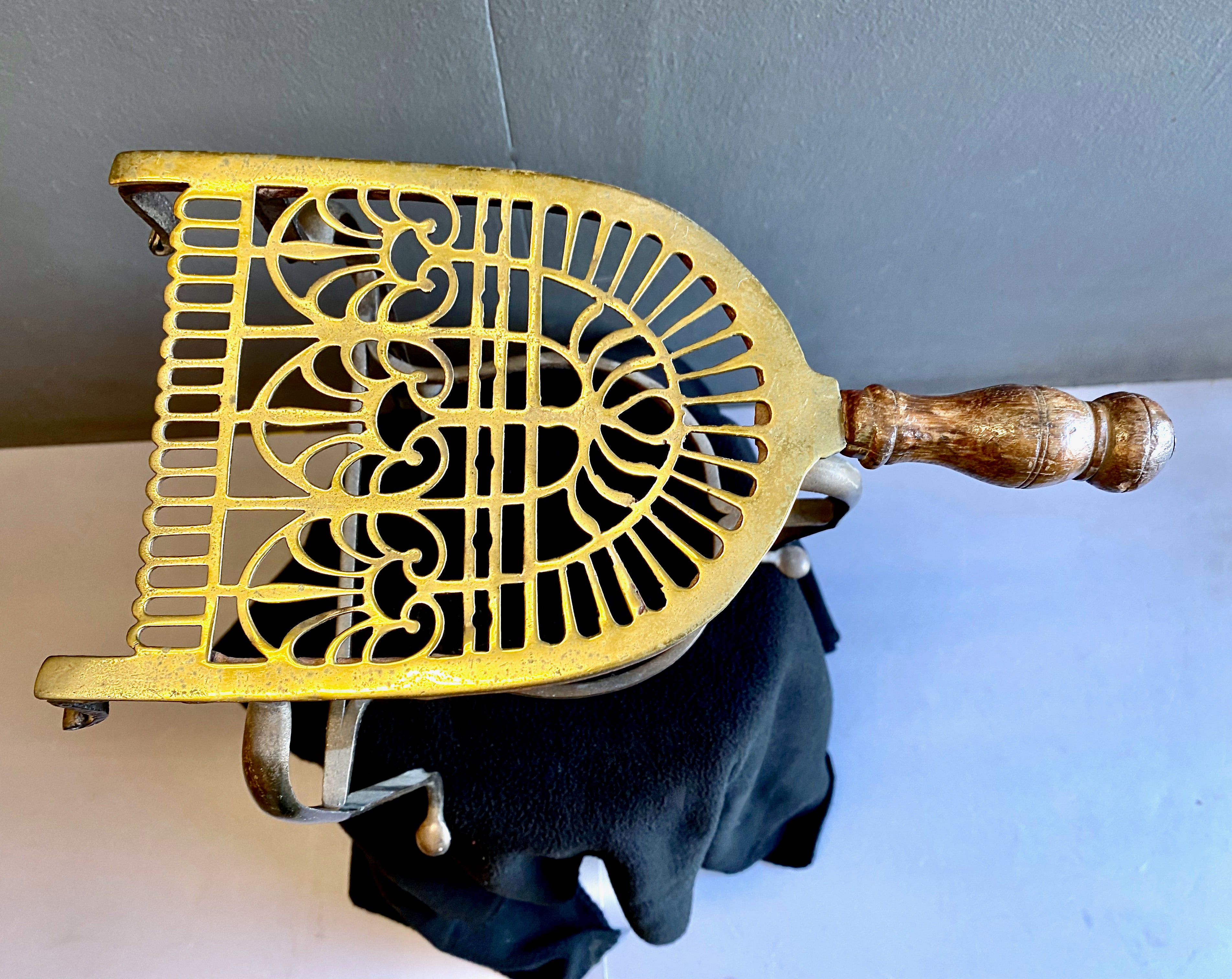 This is a good example of an 18th century pierced brass and wrought iron fireplace trivet. The tall profile of the trivet gives it a delicate presence and makes it highly decorative. All 18th century homes were equipped with trivets as they were