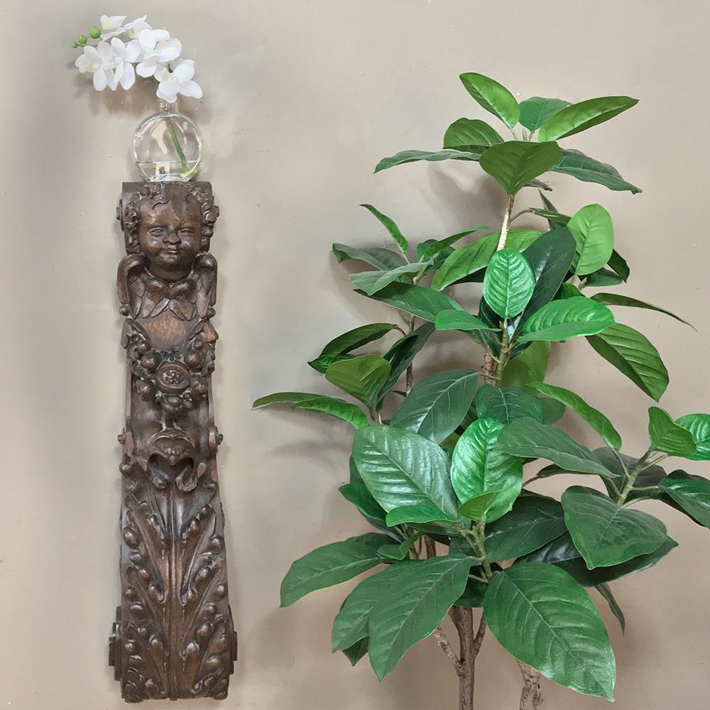 La scultura del pilastro del 18° secolo è una meraviglia dell'arte dello scultore del legno! Scolpito a mano da un solido blocco di quercia secolare per durare nei secoli, l'artista ha abilmente raffigurato gli angeli, la robia e le foglie d'acanto