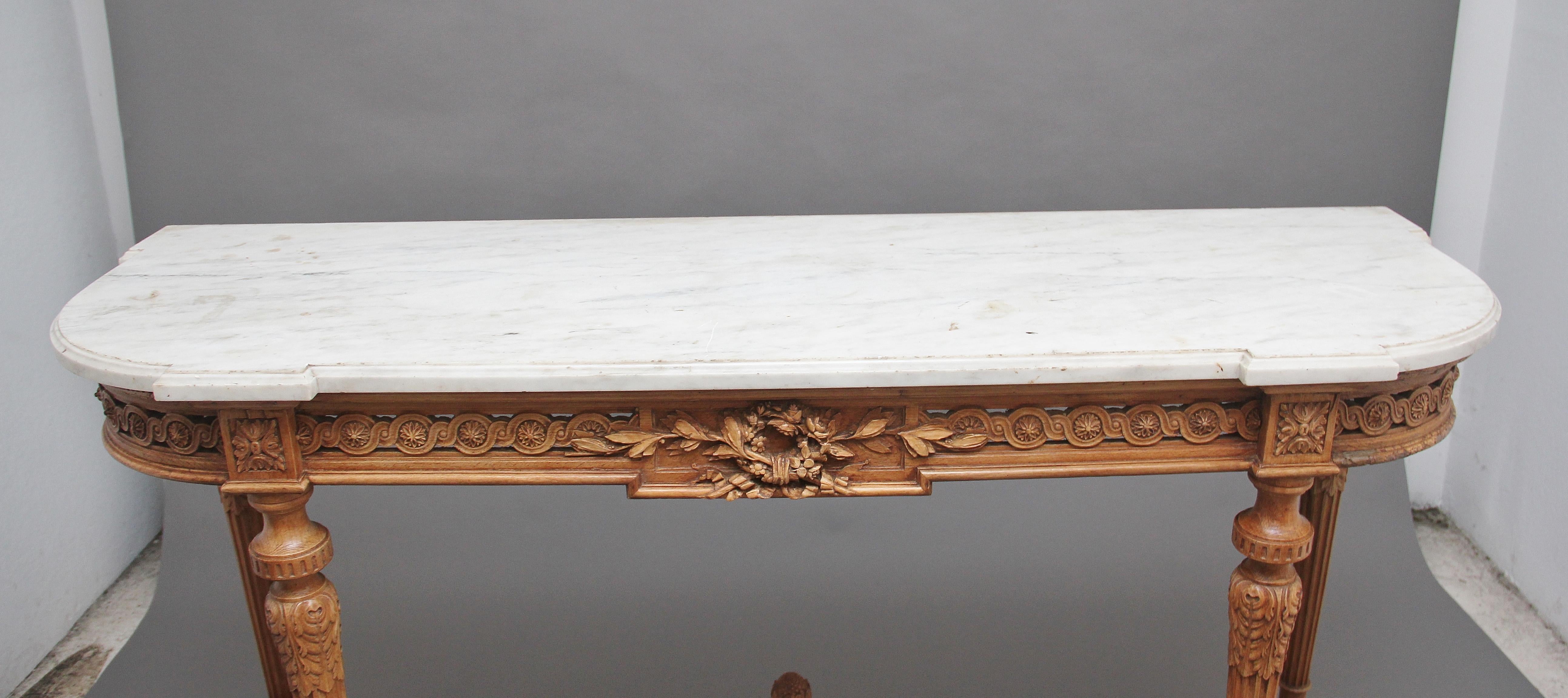 A superb quality 18th century carved pine console / serving table, having the original shaped and moulded white marble top resting on a profusely carved frieze incorporating carved patraes, circular floral carving and a central decorative floral