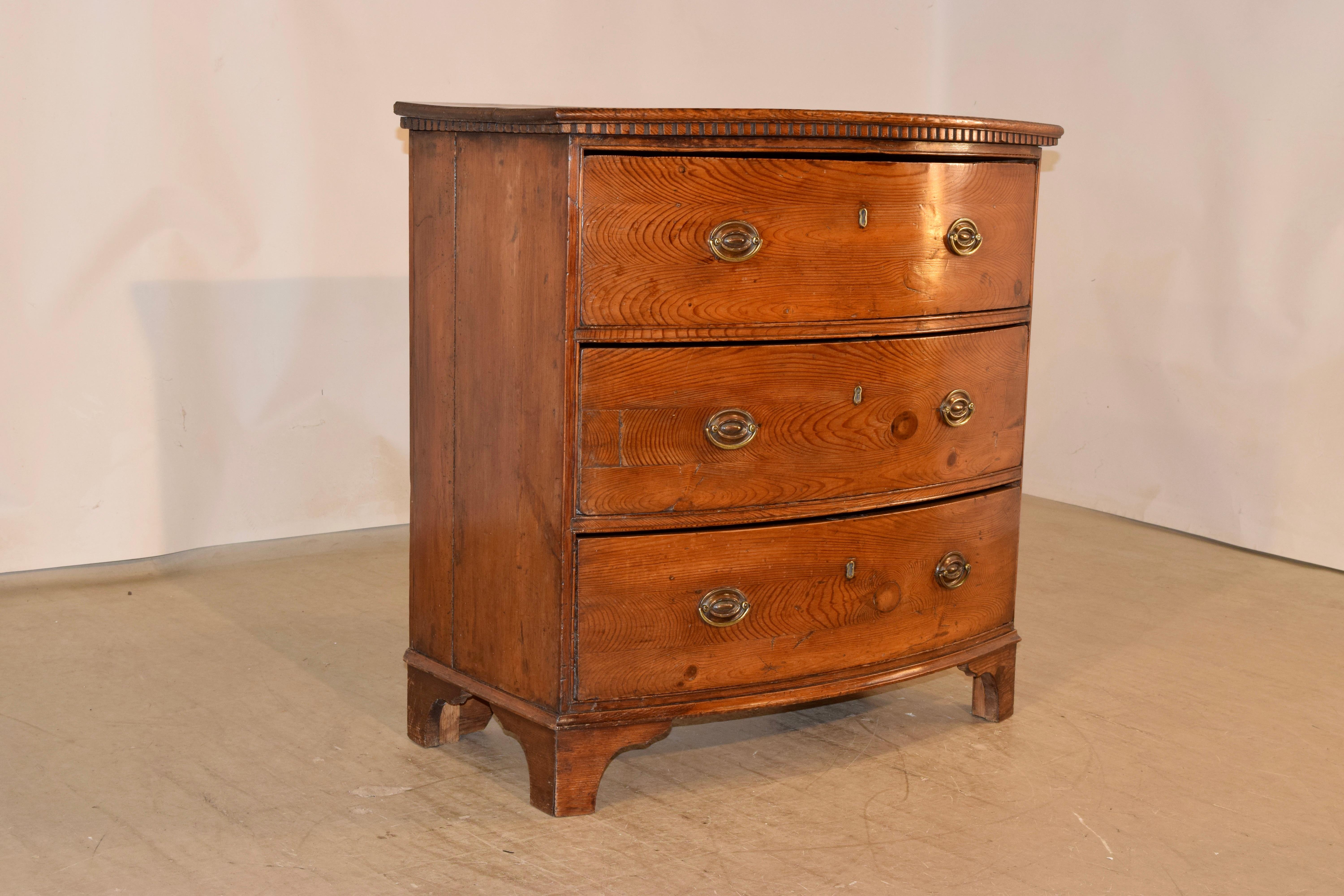 Wonderful and rare 18th century pitch pine bow front chest of drawers from England with a two plank top, which has a lovely dentil molding underneath the top edge and following down to simple sides and three drawers in the front. The case is