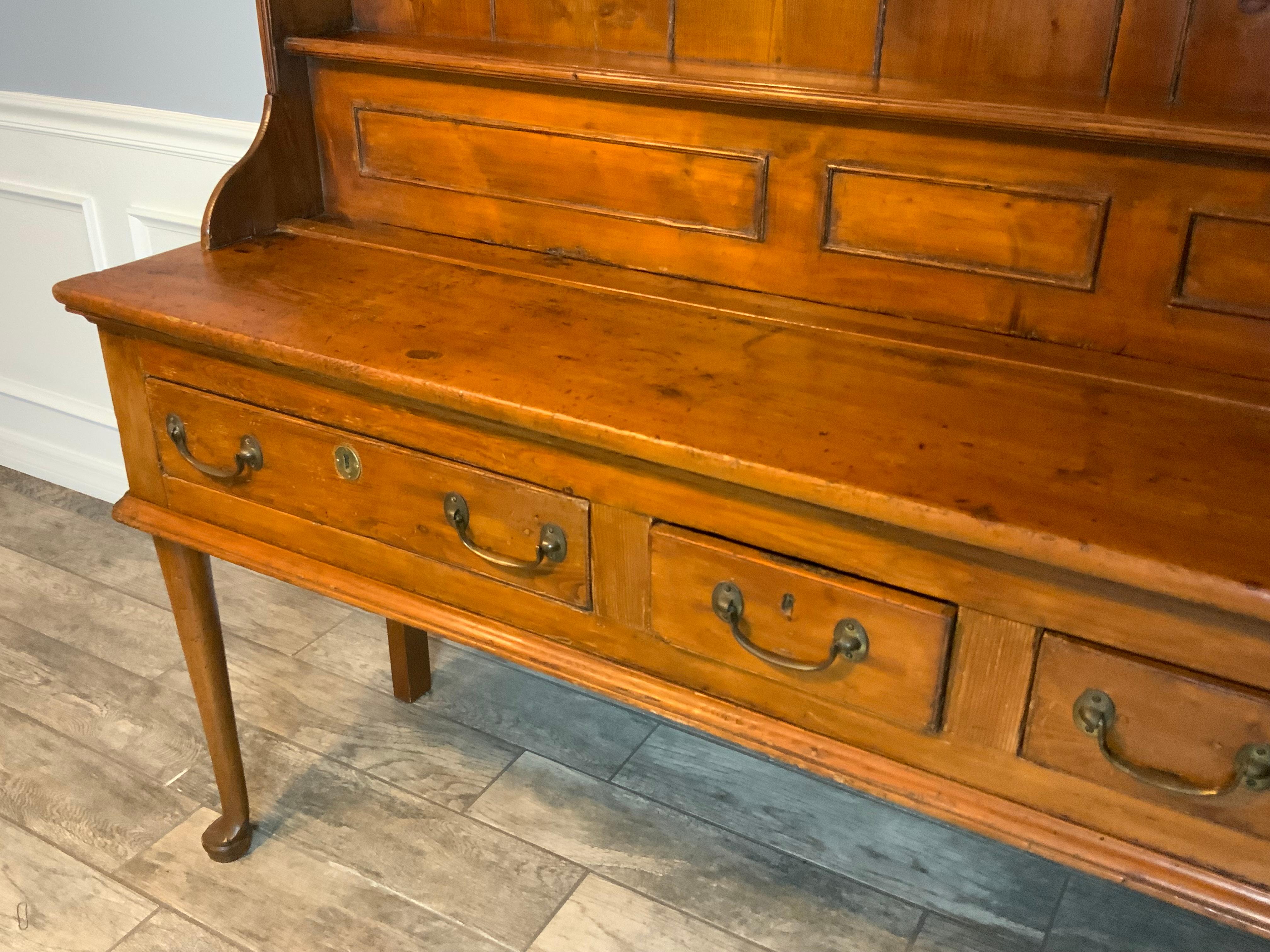  Very attractive two piece mid 18th century Pine Welsh Dresser.  Original hardware and drawer locks are intact.   Very good condition with an excellent color and aged patina to the old refinish.  Graduated size shelf plate racks at 5 1/4”, 5”, and 4