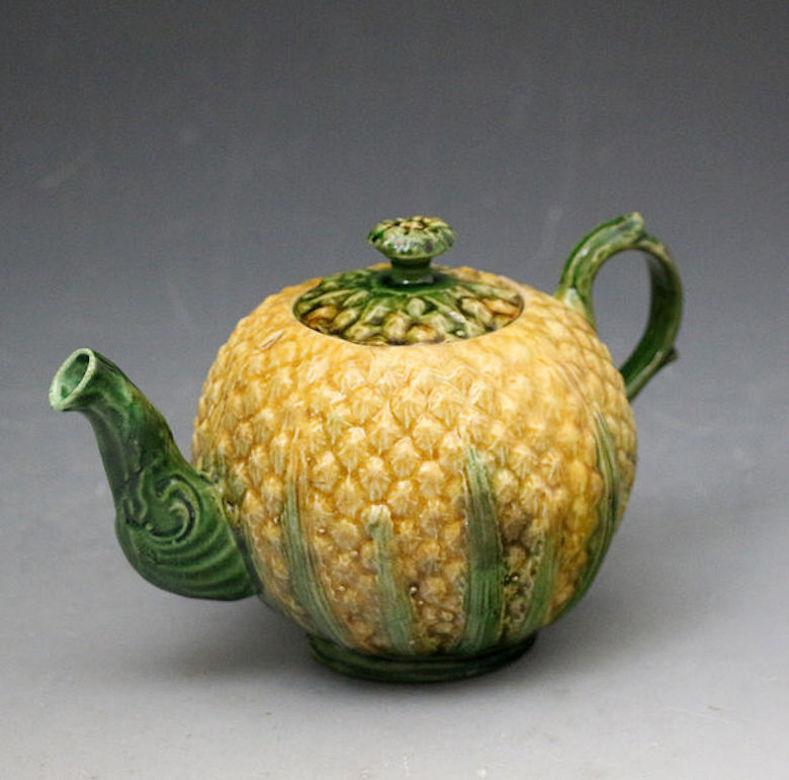 Earthenware lead glazed creamware bodied relief molded teapot in the Pineapple pattern.
The pineapple pattern was produced at the Whieldon, Greatbatch and Wedgewood Potteries in the mid-18th century period. 

Note: The fruit first appeared in
