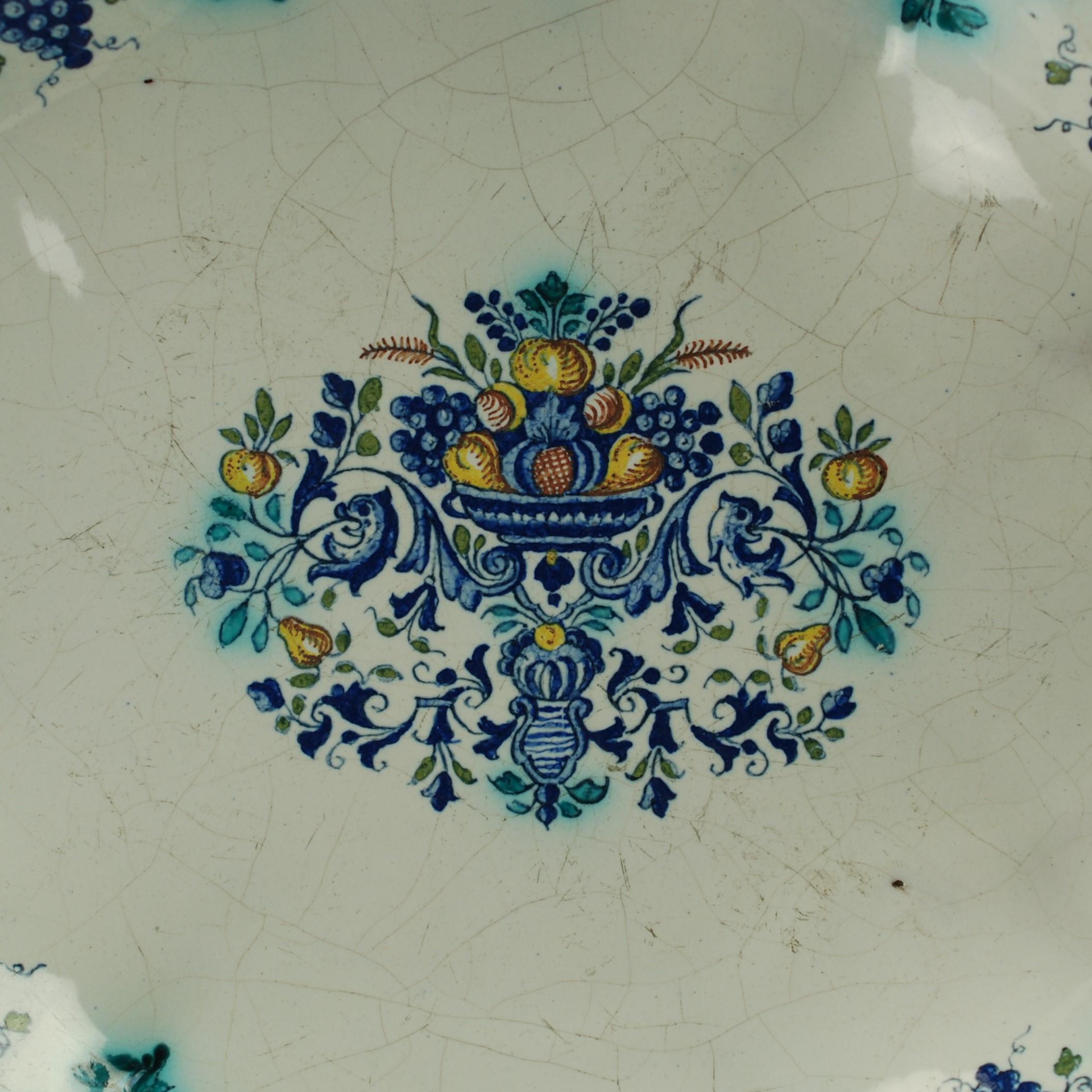 This early 18th century tin glazed earthenware platter was made by the Hannong ceramics factory in Strasbourg, France. Hannong was founded in 1721 by Charles-François Hannong and remained in the family until closing in 1780. Faience produced in the