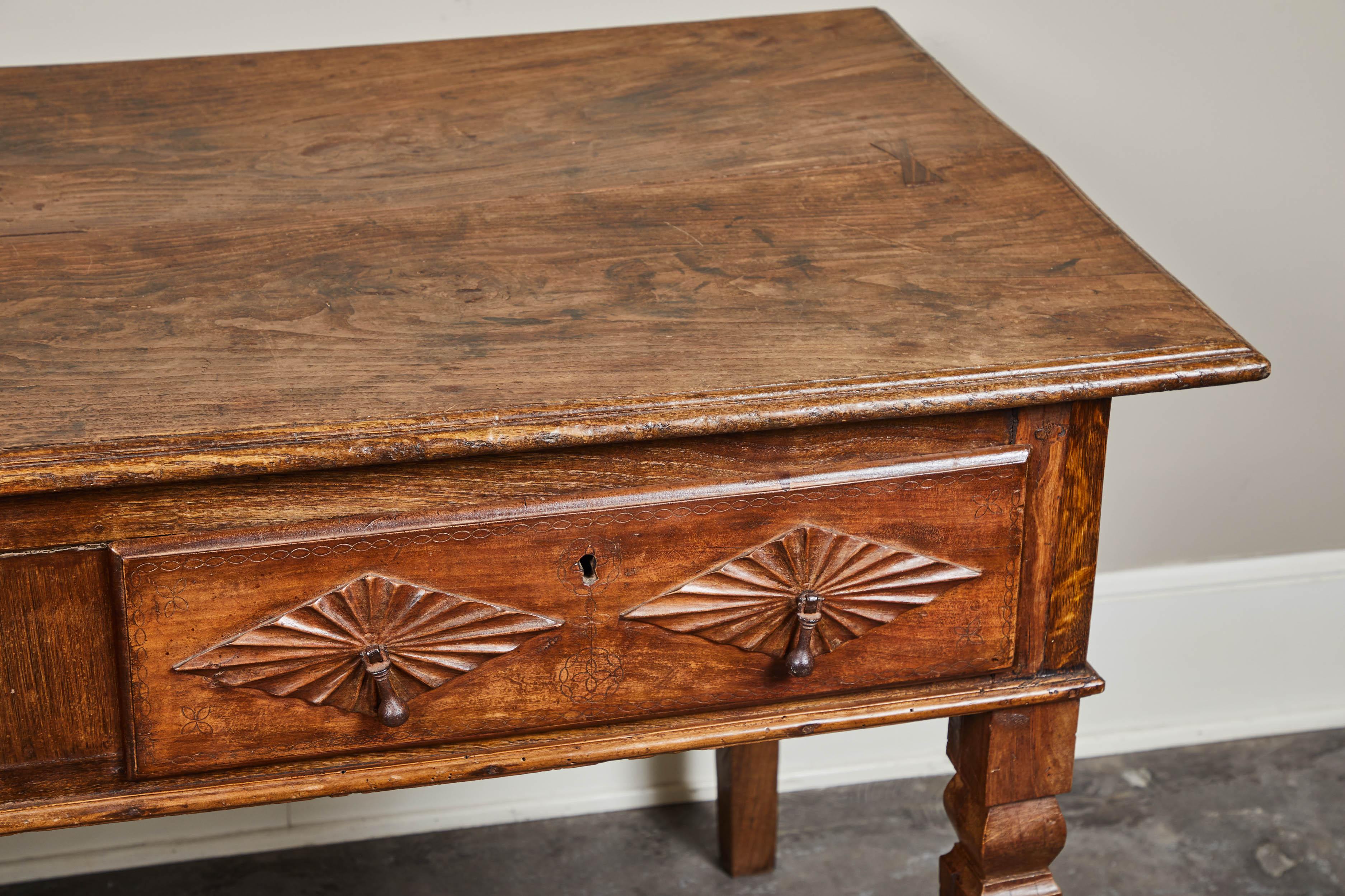 A handsome 18th century Portuguese 2-drawer table featuring highly decorated drawers. Each drawer features an engraved geometric pattern as well as diamond shapes.