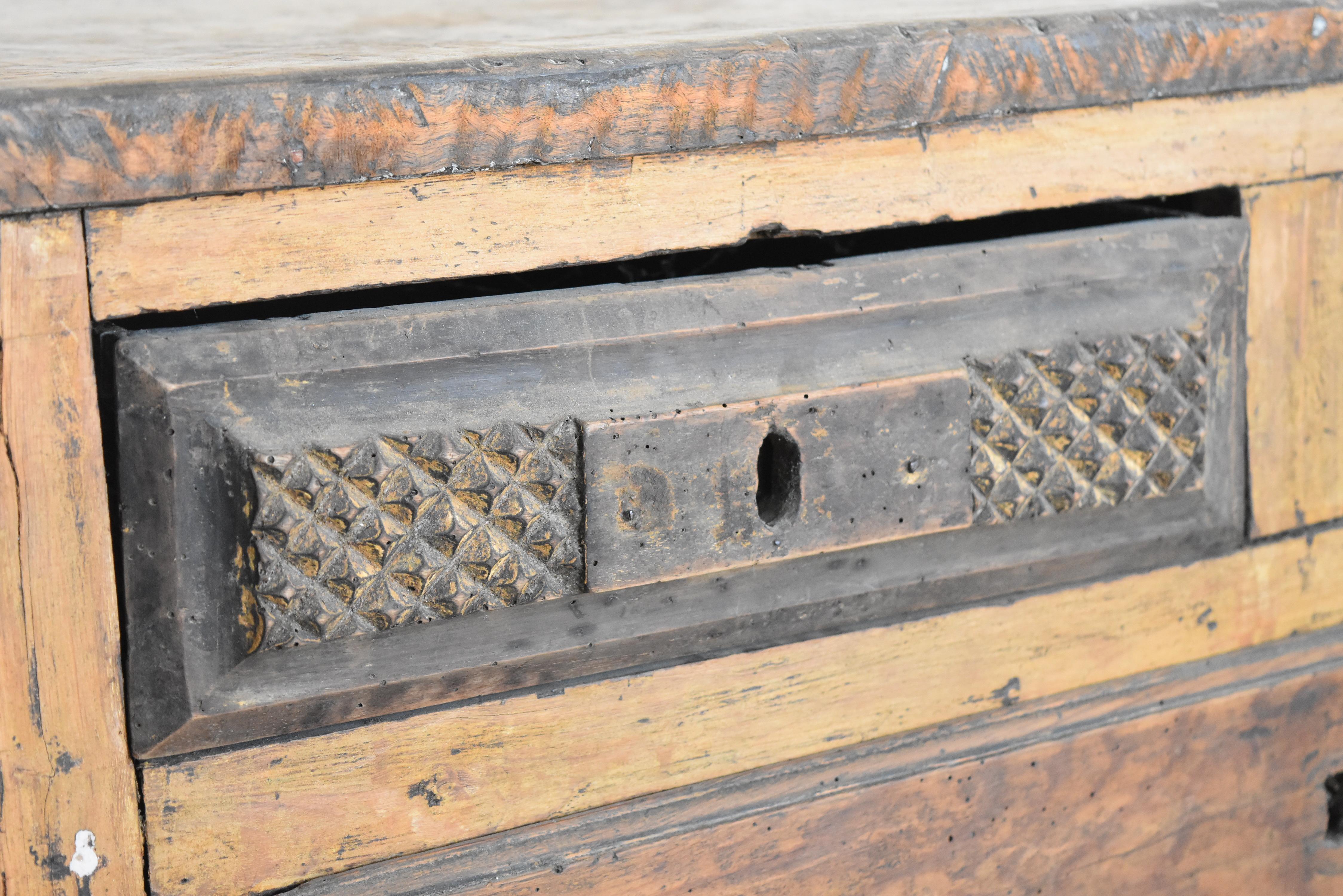 This is a very well constructed Portuguese low rustic chest comprised of both walnut and chestnut woods. The top two drawers have great carved front faces with otherwise simple non carved design on the rest of the chest.