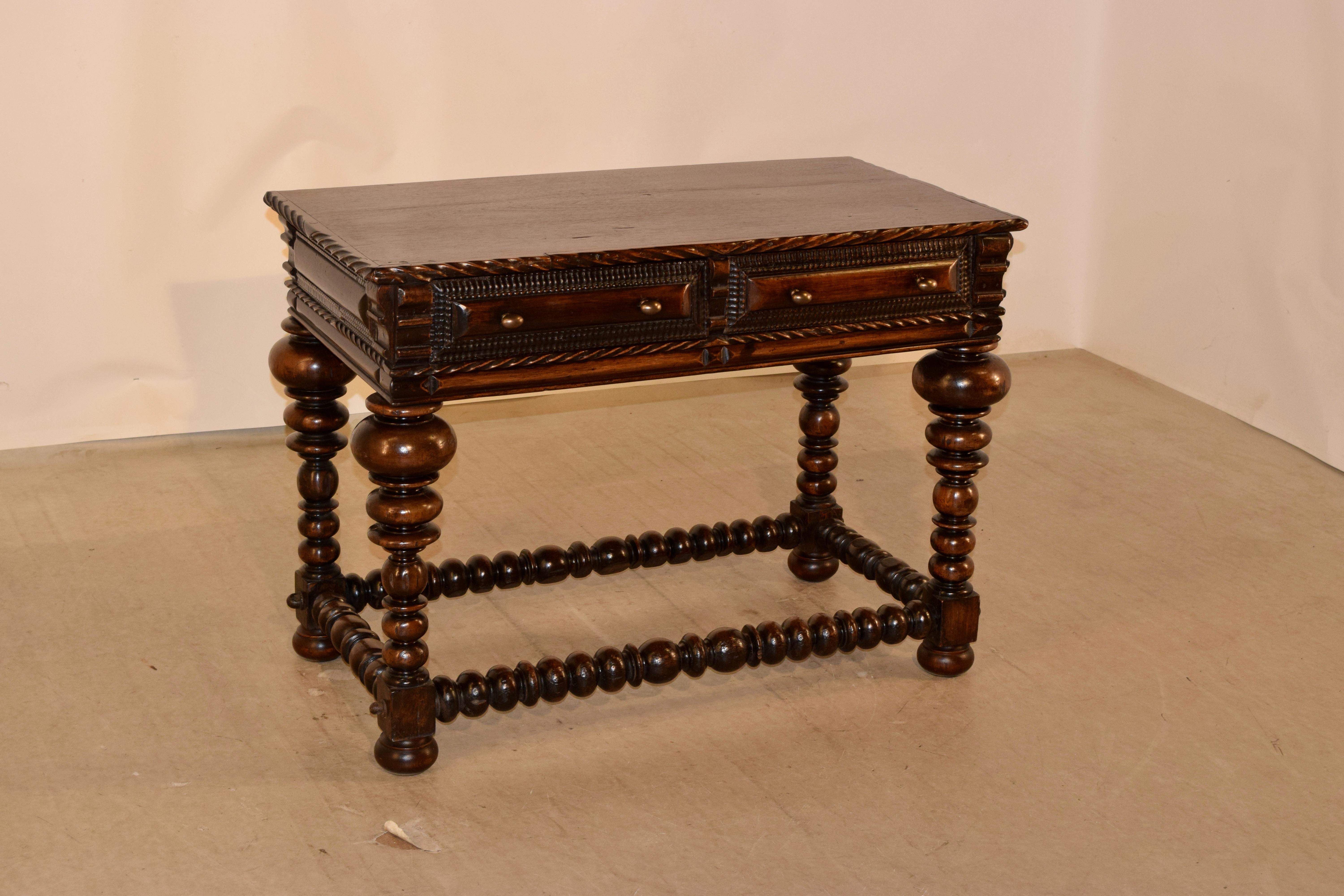 18th century Portuguese writing table with fabulous hand turned legs and stretchers. The top features a single board top with applied carved molding around the edges, following down to two drawers with cushion raised panels and hand carved beaded