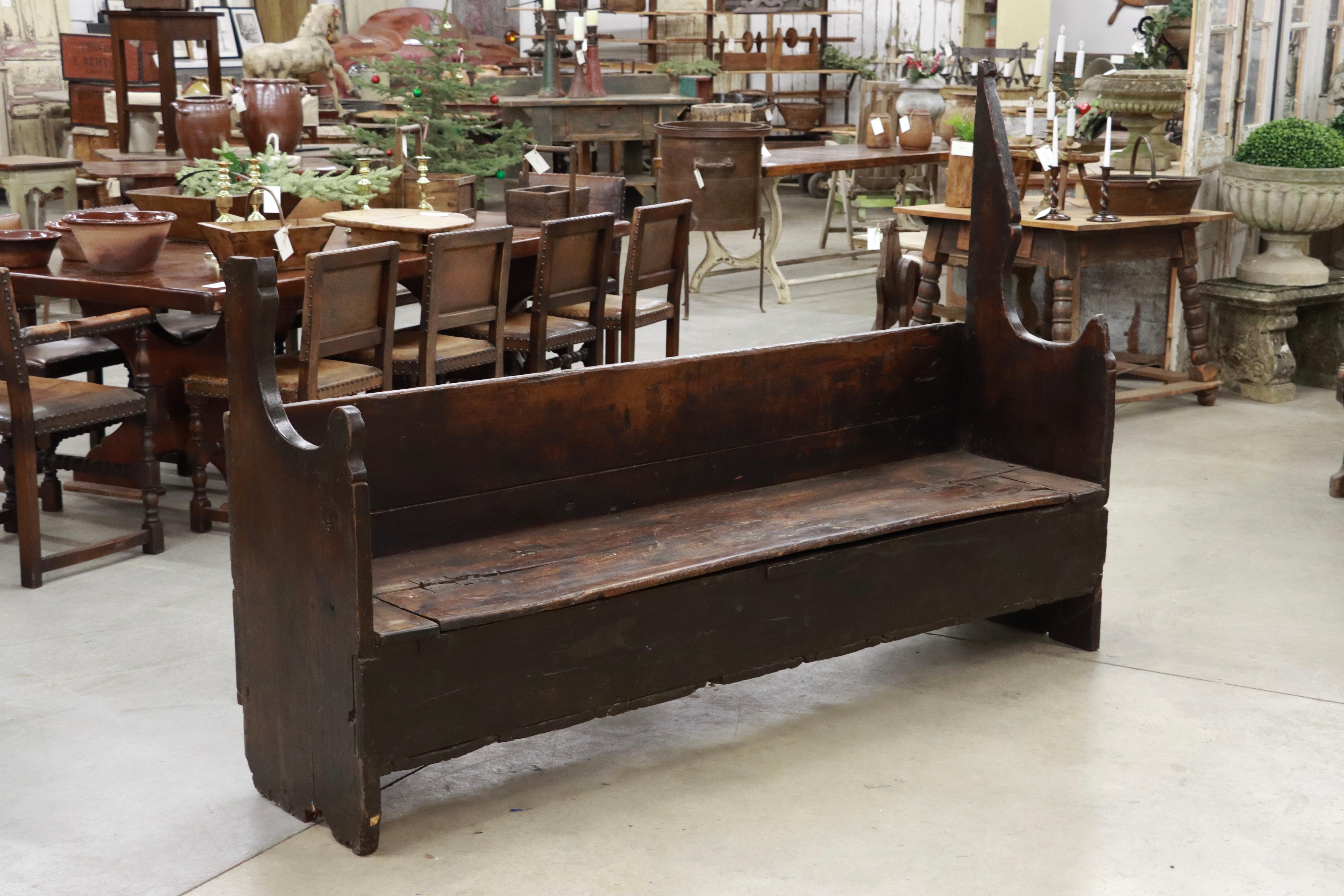 Circa 1700s primitive rustic farmhouse bench from the Cataluña region, Spain.

The patina is superb with its dark rich finish acquired over centuries of use. It is of a solid plank construction with a hinged lid for storage. The original ancient