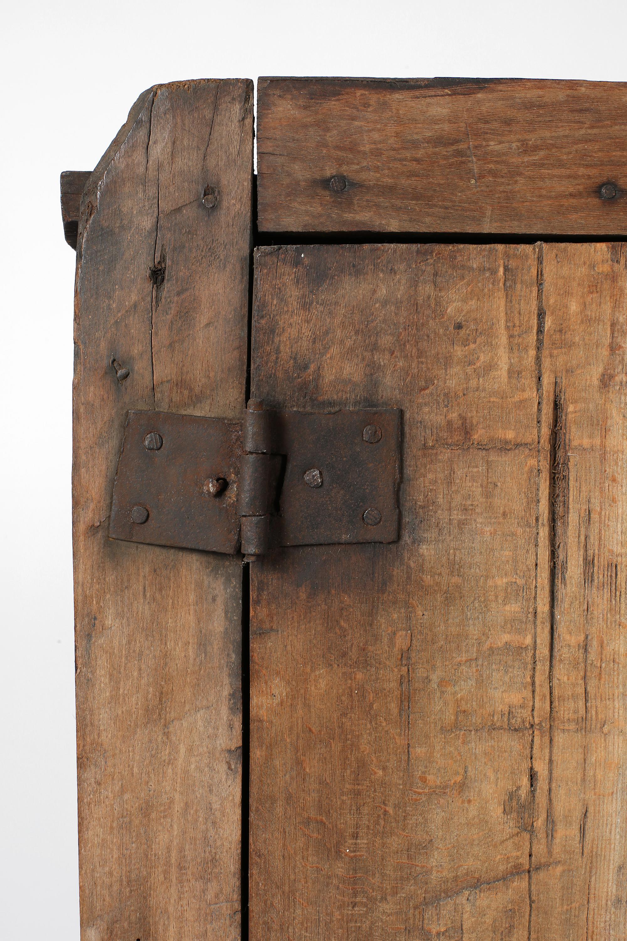 A primitive, late 18th century cupboard originating from the Carpathian Mountains. Constructed from roughly hewn hardwood timber, with four single plank doors which open to reveal four shelves within. Central European, c. 1780.