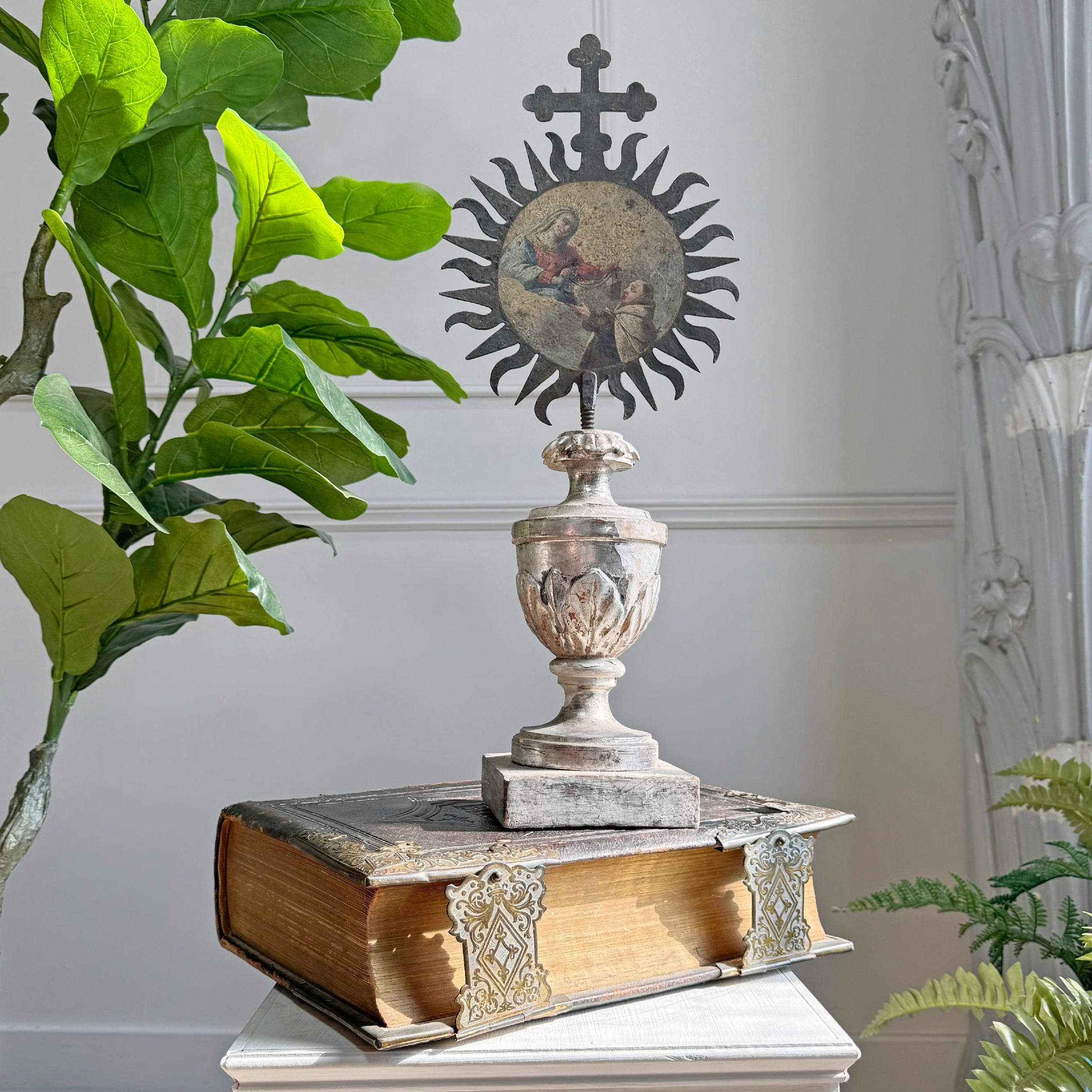 A rare and exquisite 18th century iron processional sunburst with a painted central image of Holy Mother Mary presenting the rosary to Saint Dominic to one side and Ave Maria to the back, mounted in a magnificent silver gilt over gesso, carved