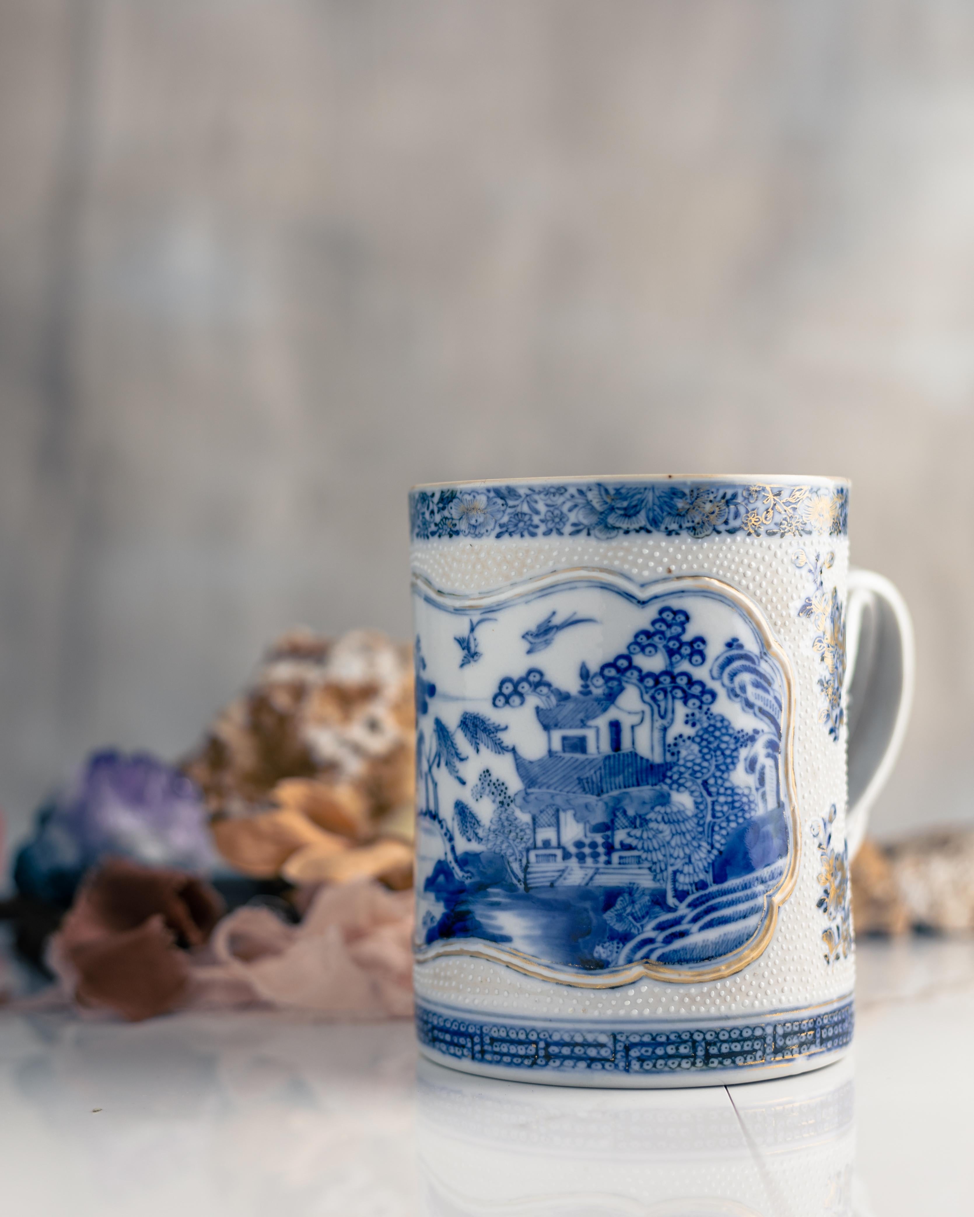 A large blue and white Chinese export porcelain mug, made during the Qianlong Period circa 1775.

This Chinese export porcelain mug is beautifully painted in cobalt blue glaze. The central design shows a Chinese landscape with a lone fisherman in