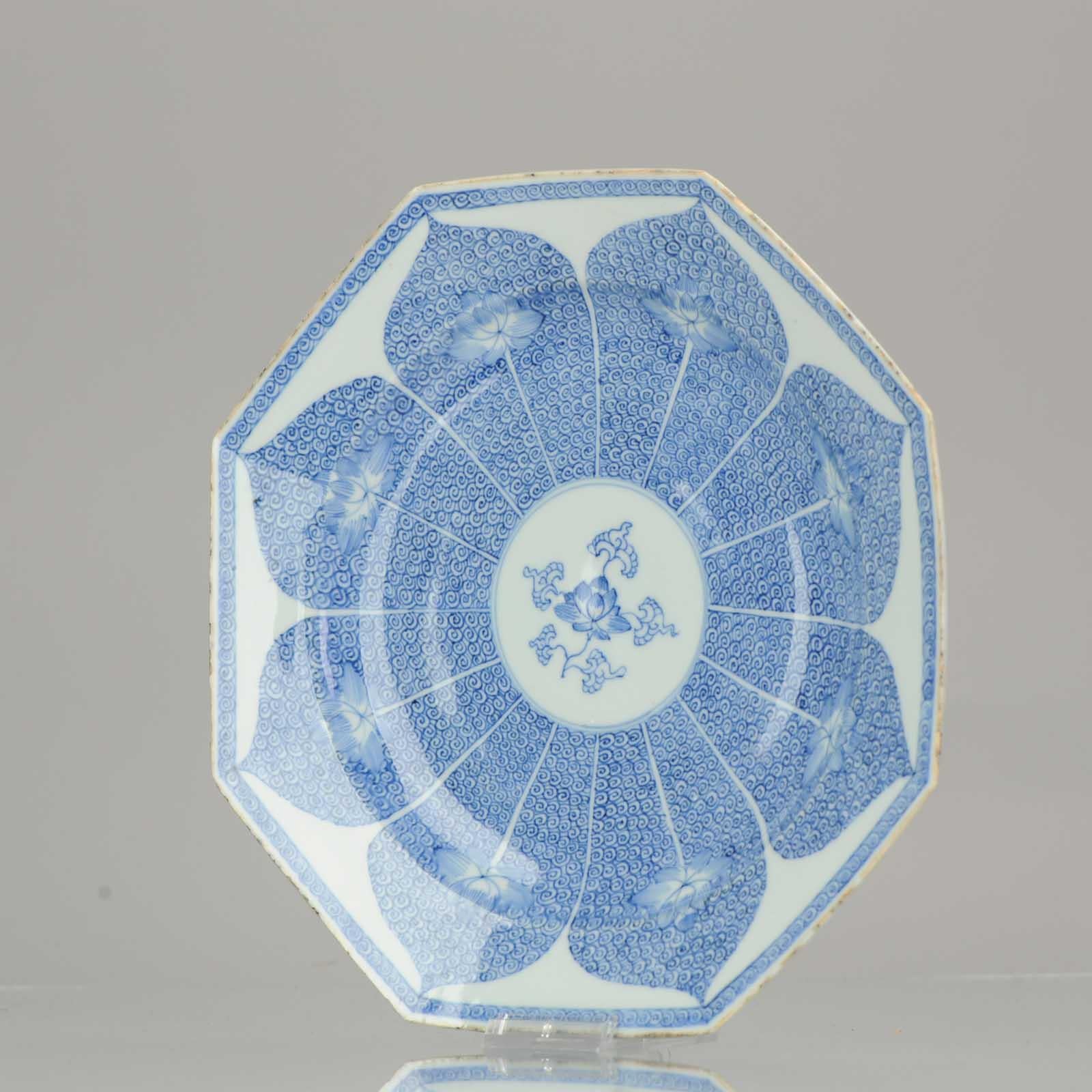 Blue and white octagonal export plate decorated in the centre with a stylized spray of lotus flower, bordered by lotus petals enclosing lotus flowers on a scroll-work ground.

This design was used in Chinese armorial porcelain, for an illustrated