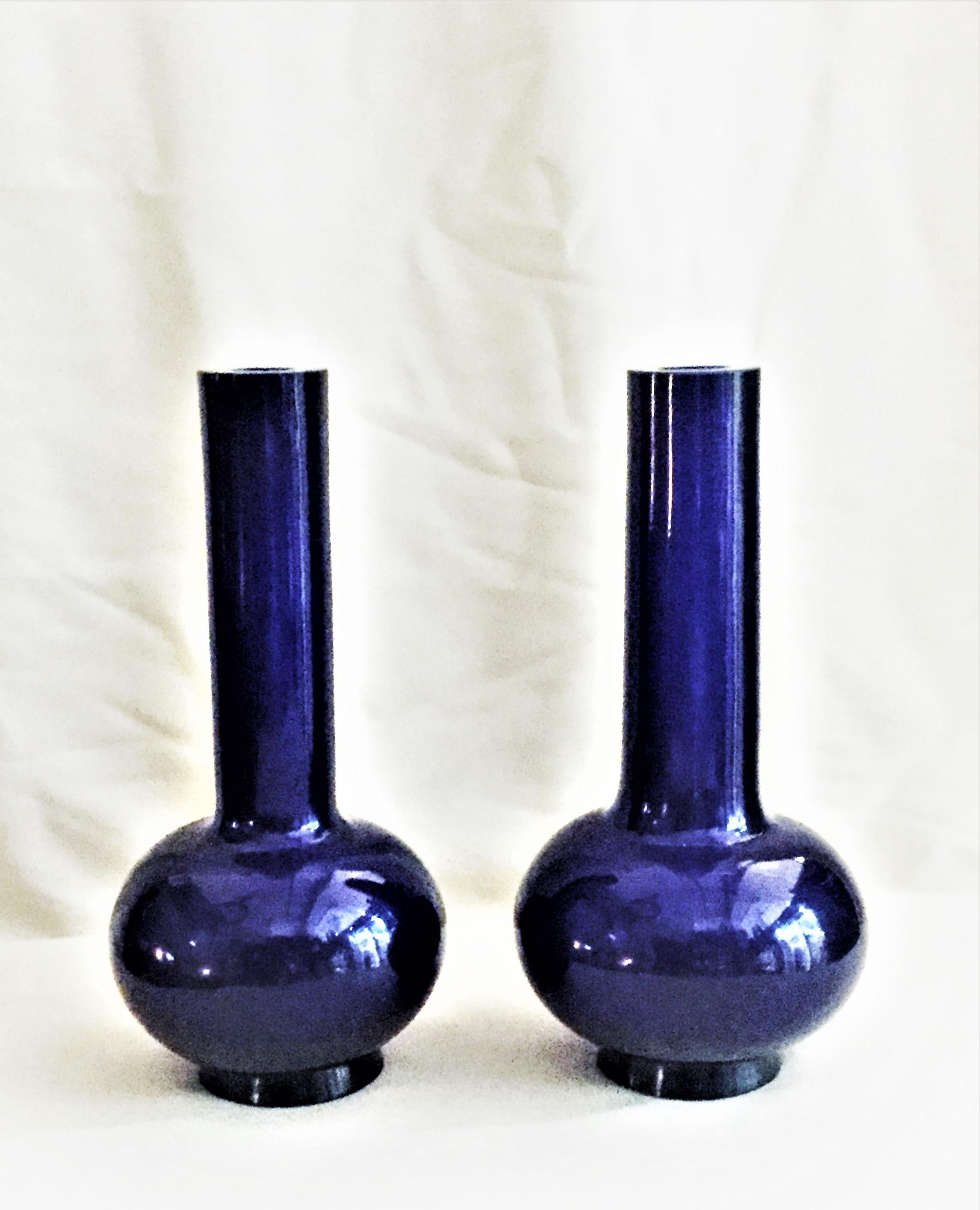 This striking pair of Peking glass vases have a straight cylindrical neck and globular body. The smoothly curved classical form creates a dramatic silhouette accentuated by the deep, translucent cobalt-blue color. 

Peking glass was an art form