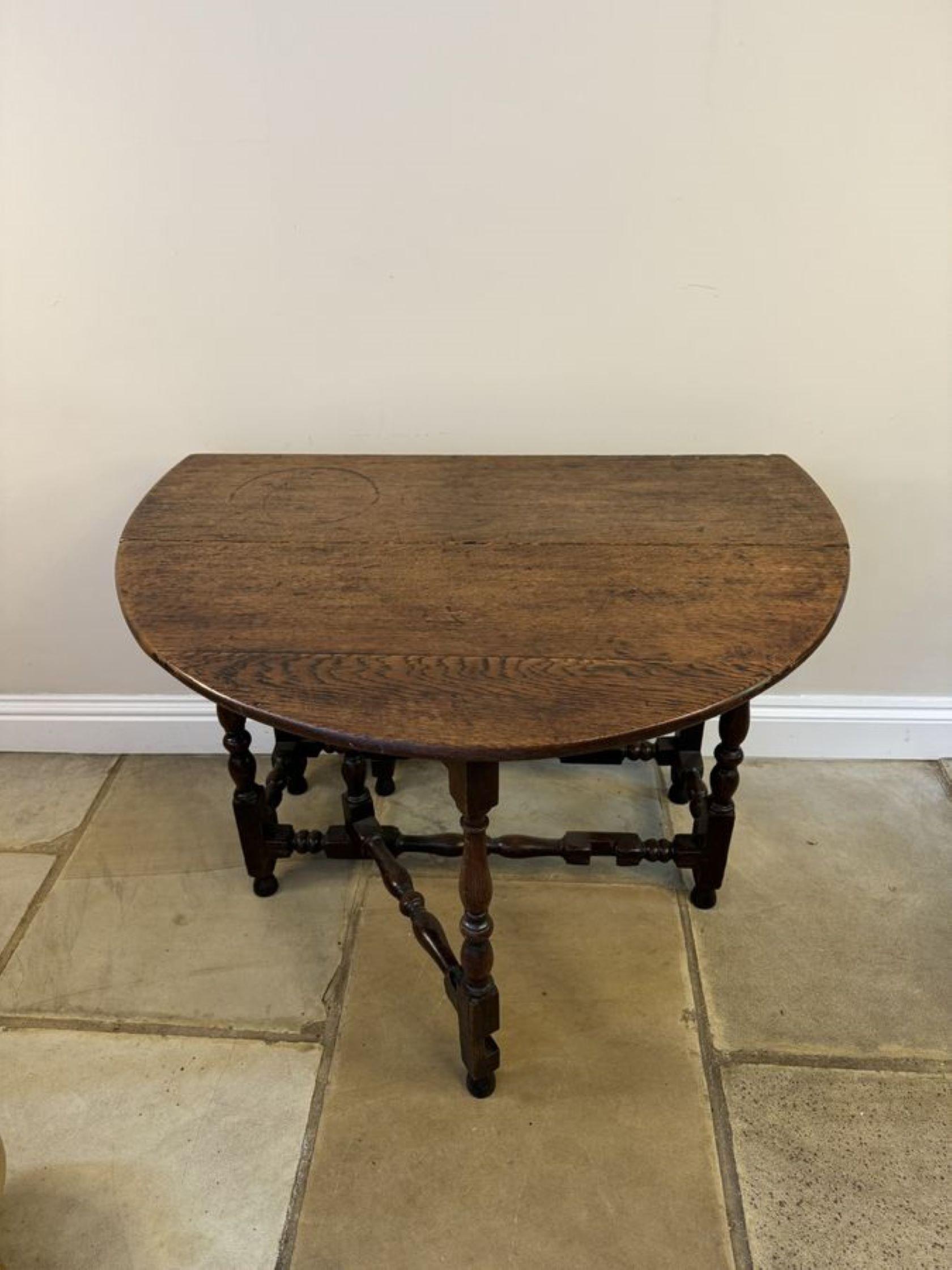Table de salle à manger en chêne antique du 18e siècle, avec un plateau en chêne de qualité et deux feuilles ovales soutenues par deux pieds en forme de porte avec des supports tournés, des colonnes tournées en forme aux extrémités reposant sur des