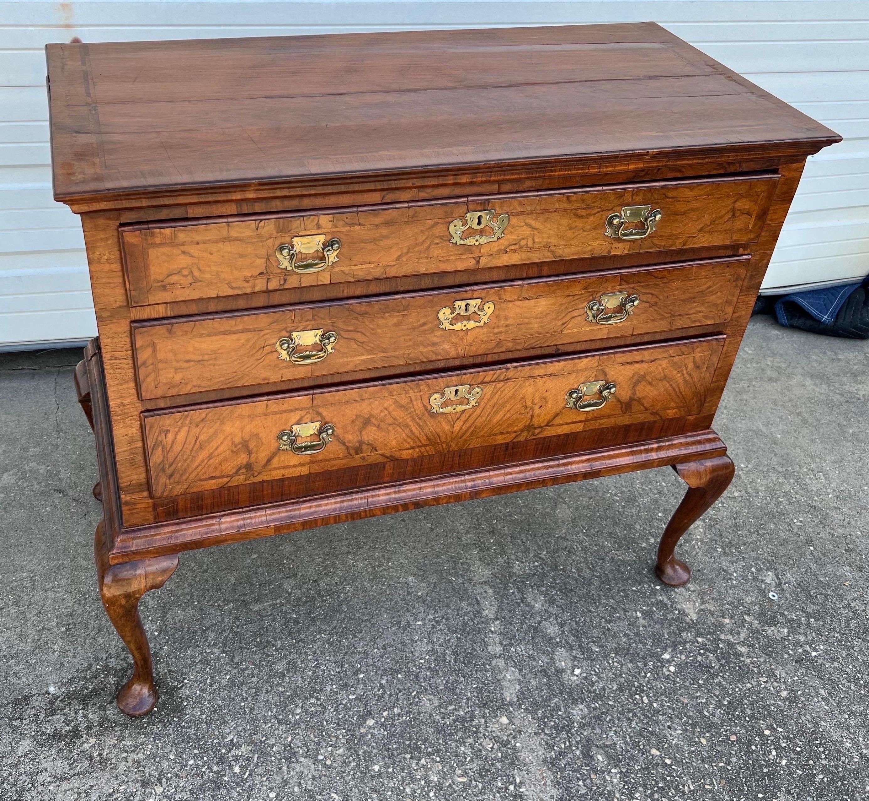 18th Century English Queen Anne crossbanded walnut chest on frame. Three herringbone inlaid drawers with original 18th century pulls on frame with Queen Anne pad feet. Top is beautifully crossbanded and herringbone inlaid. Charming old shrinkage