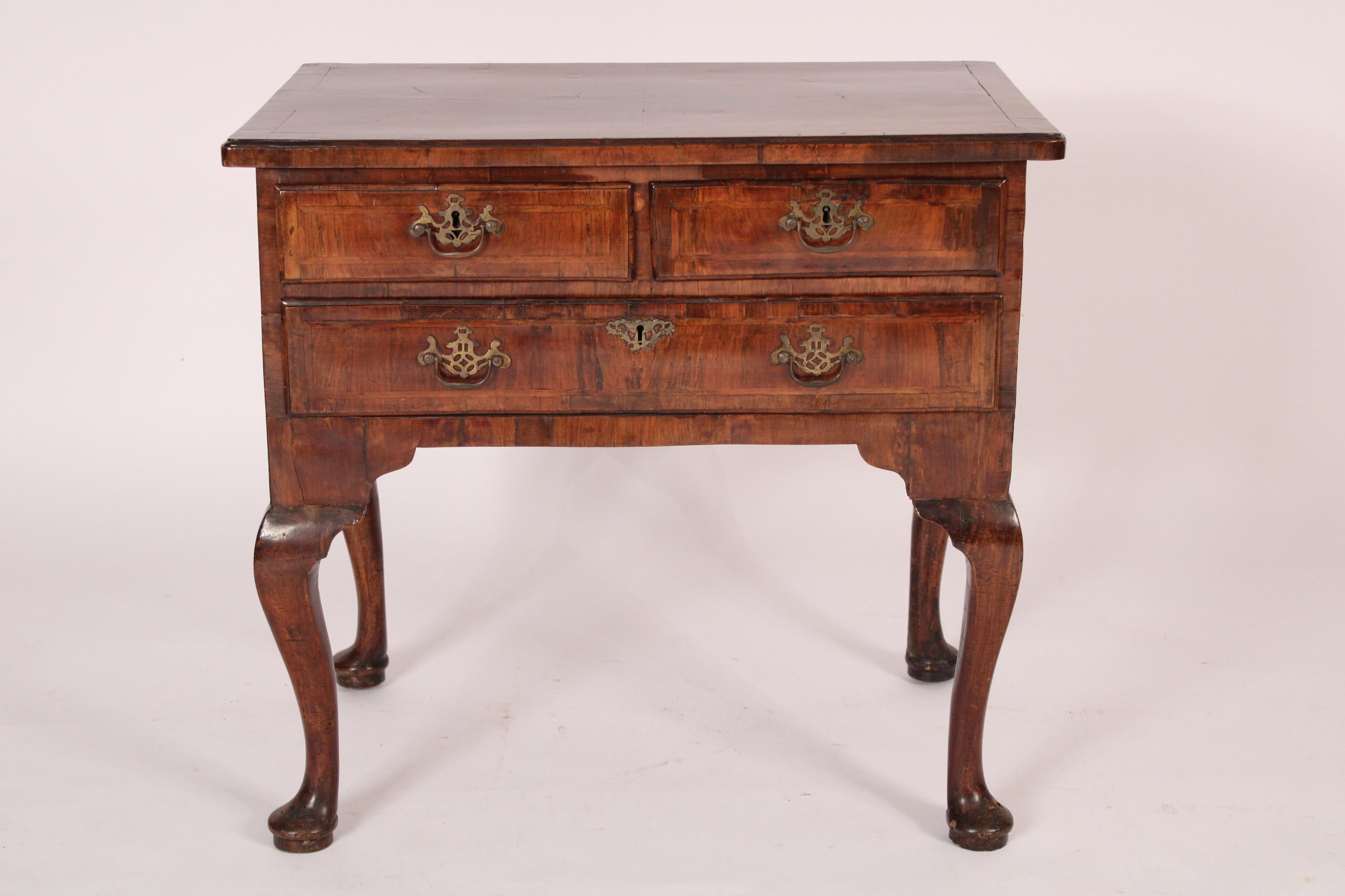 Queen Anne walnut lowboy, 18th century. With a rectangular top with rounded front corners and herringbone inlay, two top drawers over a long bottom drawer, all drawers with herringbone inlay, resting on 4 cabriole legs ending in pad feet. Nice old