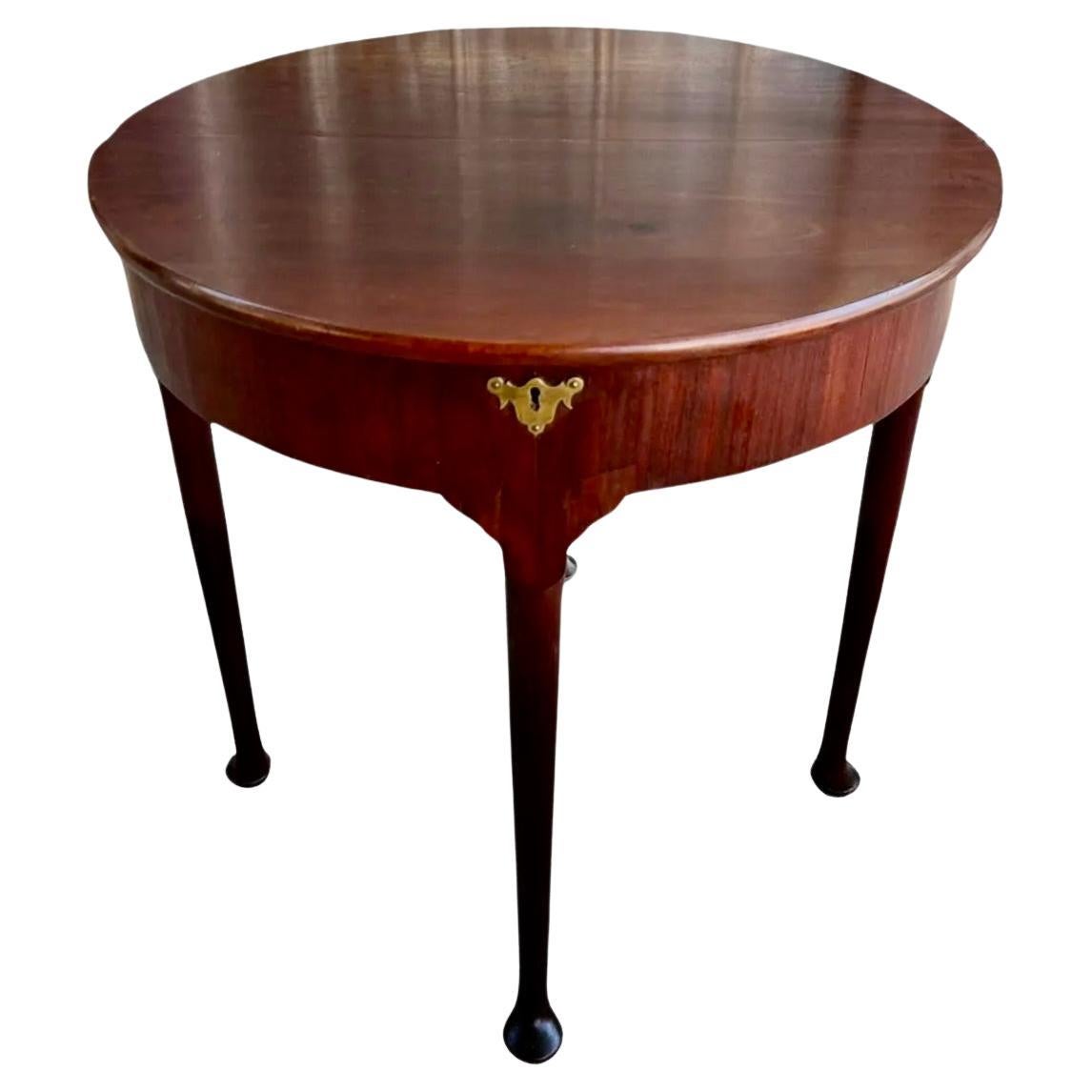 18th Century Queen Anne Mahogany demi lune flip top side table. Half round top opens to expose a circular top. Fitted with exposed brass hinges on each side and hidden hinges underneath. The top is also meant to open up for storage (there is no key).