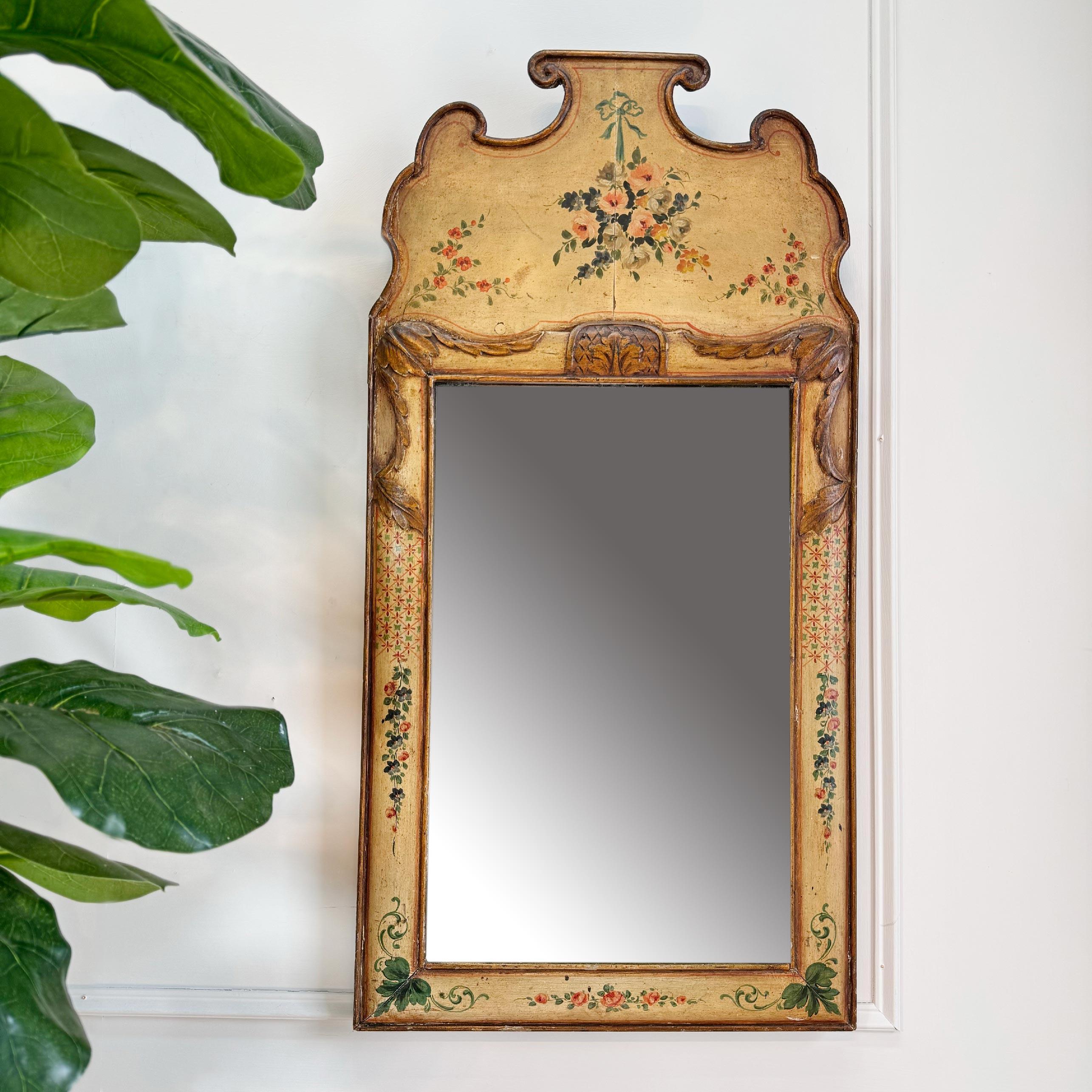 A beautiful late 18th century mirror in the Queen Anne manner, gilt over gesso flourishes and hand painted decorative elements of flowers and leaves on a soft yellow  background.



This is an absolutely beautiful mirror and retains its original