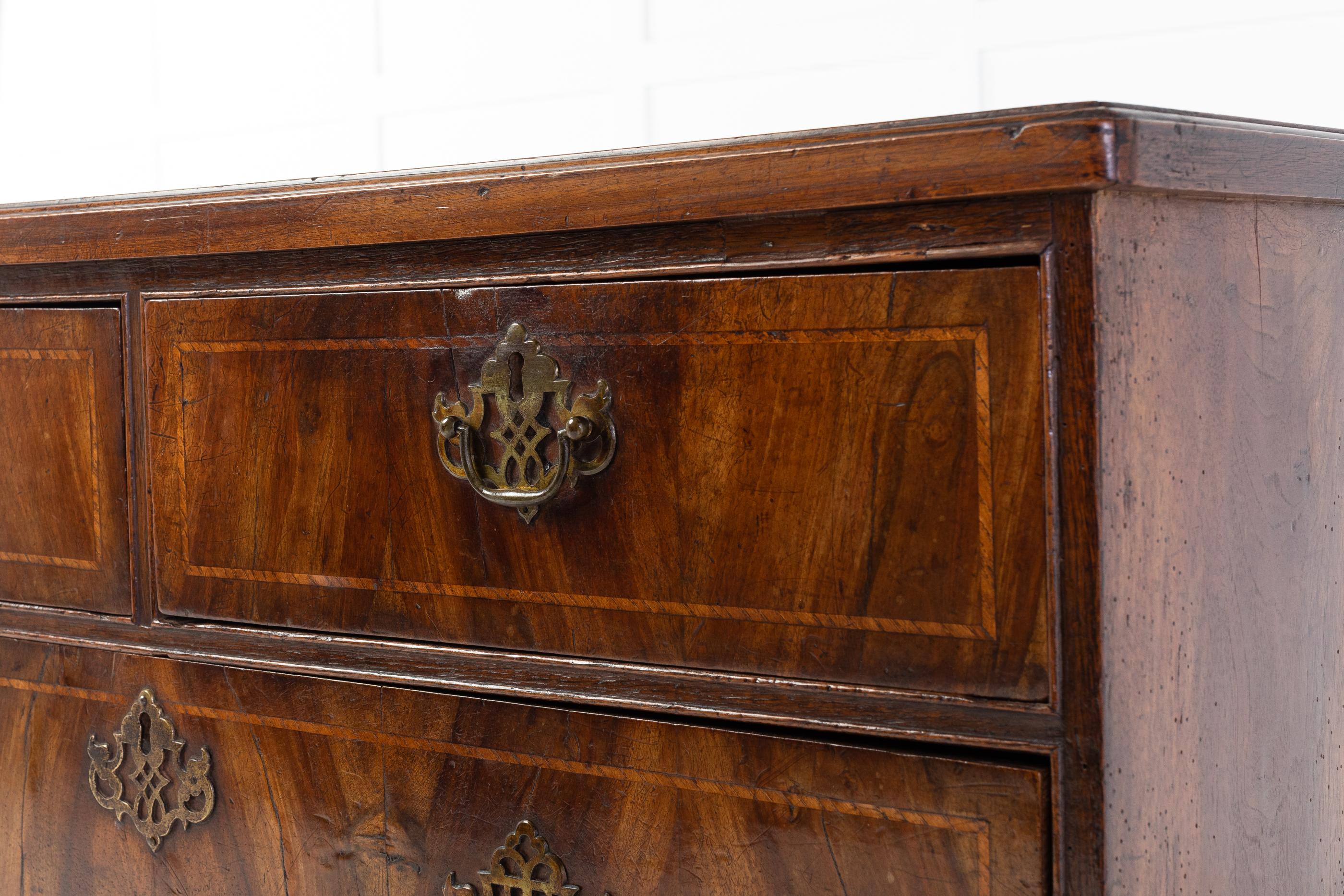 18th century Queen Anne chest of drawers with original handles. The chest has two top drawers over three graduating drawers. The drawers and top have a fine inlay. Standing on bun feet.

A lovely coloured chest of drawers.