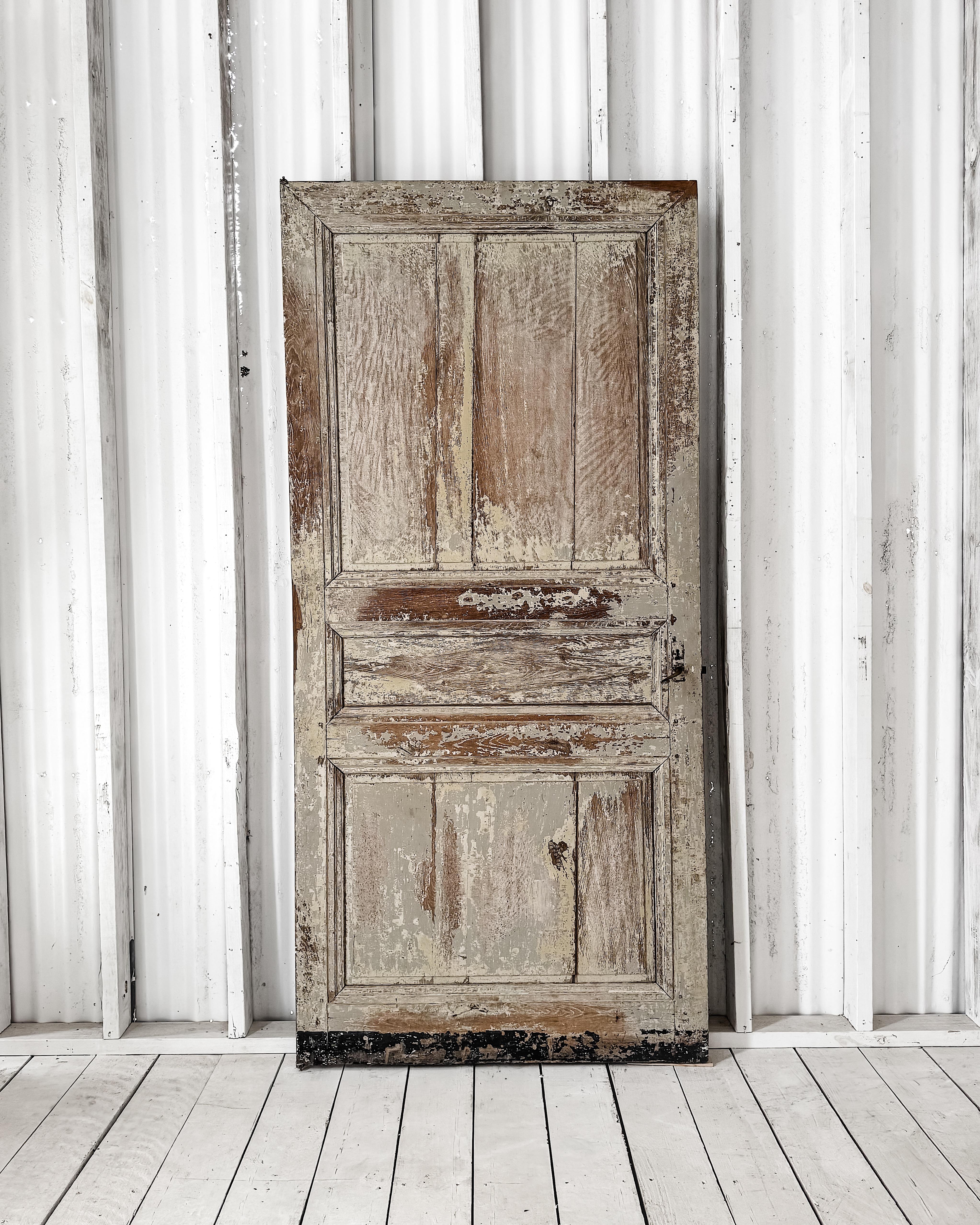 Risalente al XVIII secolo, questa porta-finestra recuperata è un esempio straordinario di artigianato in legno massiccio. La sua classica struttura a tre pannelli è impreziosita da un centro a diamante sottilmente rialzato e conserva gli strati