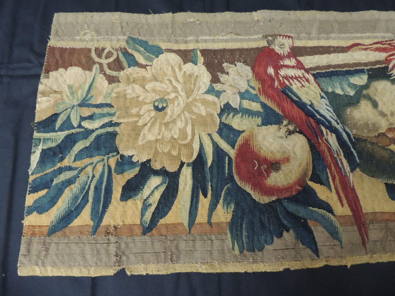 18th century red and blue Aubusson tapestry panel.
Tapestry panel depicting red and blue bird with dark green leaves surrounded by sunflowers and fruits.
In shades of red, blue, gold, hunter green and yellow.
Sold as is.
Size: 13.5