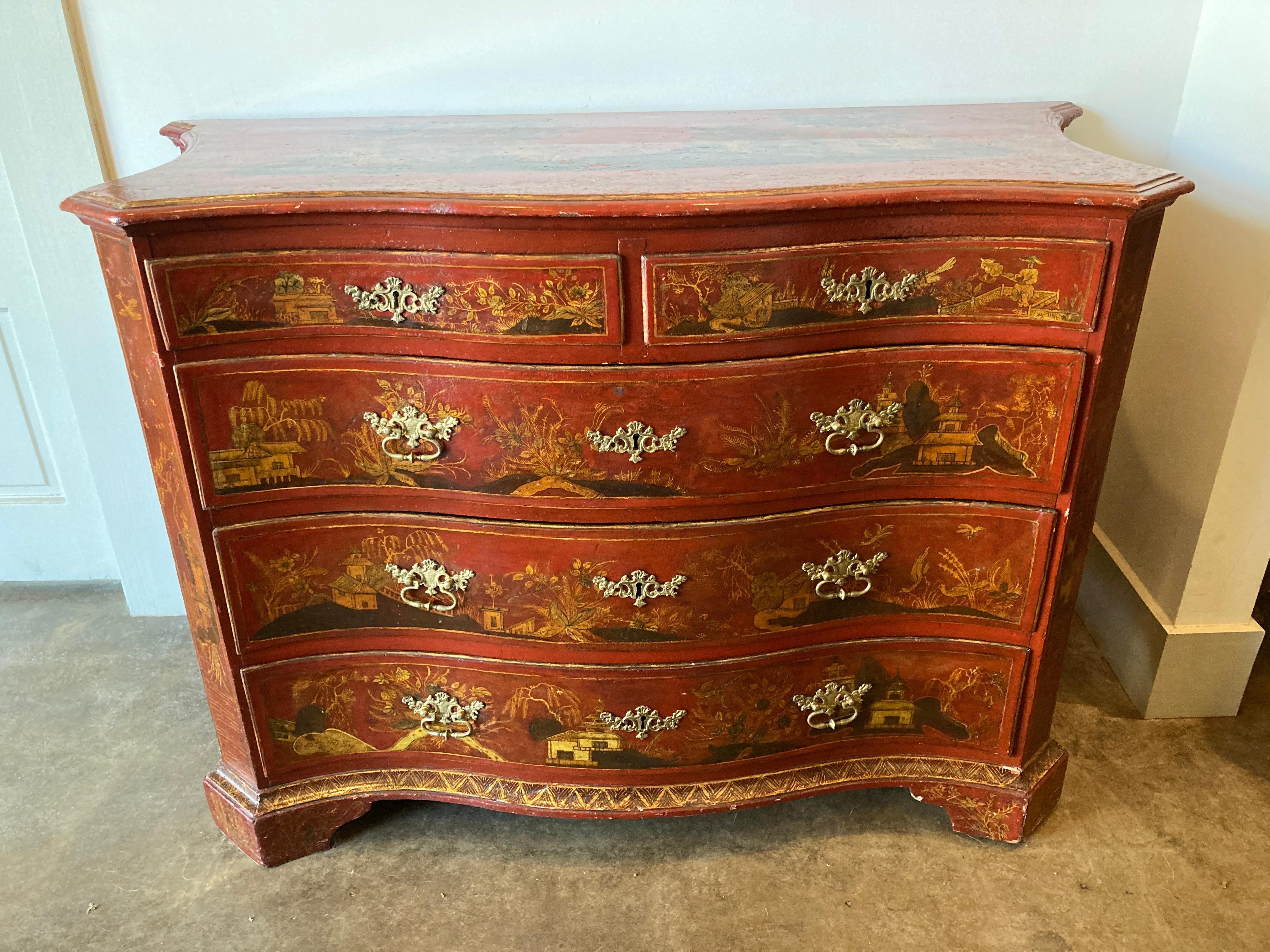 Red lacquered Italian commode with bucolic and chinoiserie decoration in paint and gilding. This 18th century chest of drawers is a serpentine shape with curved sides and has five drawers with period hardware.