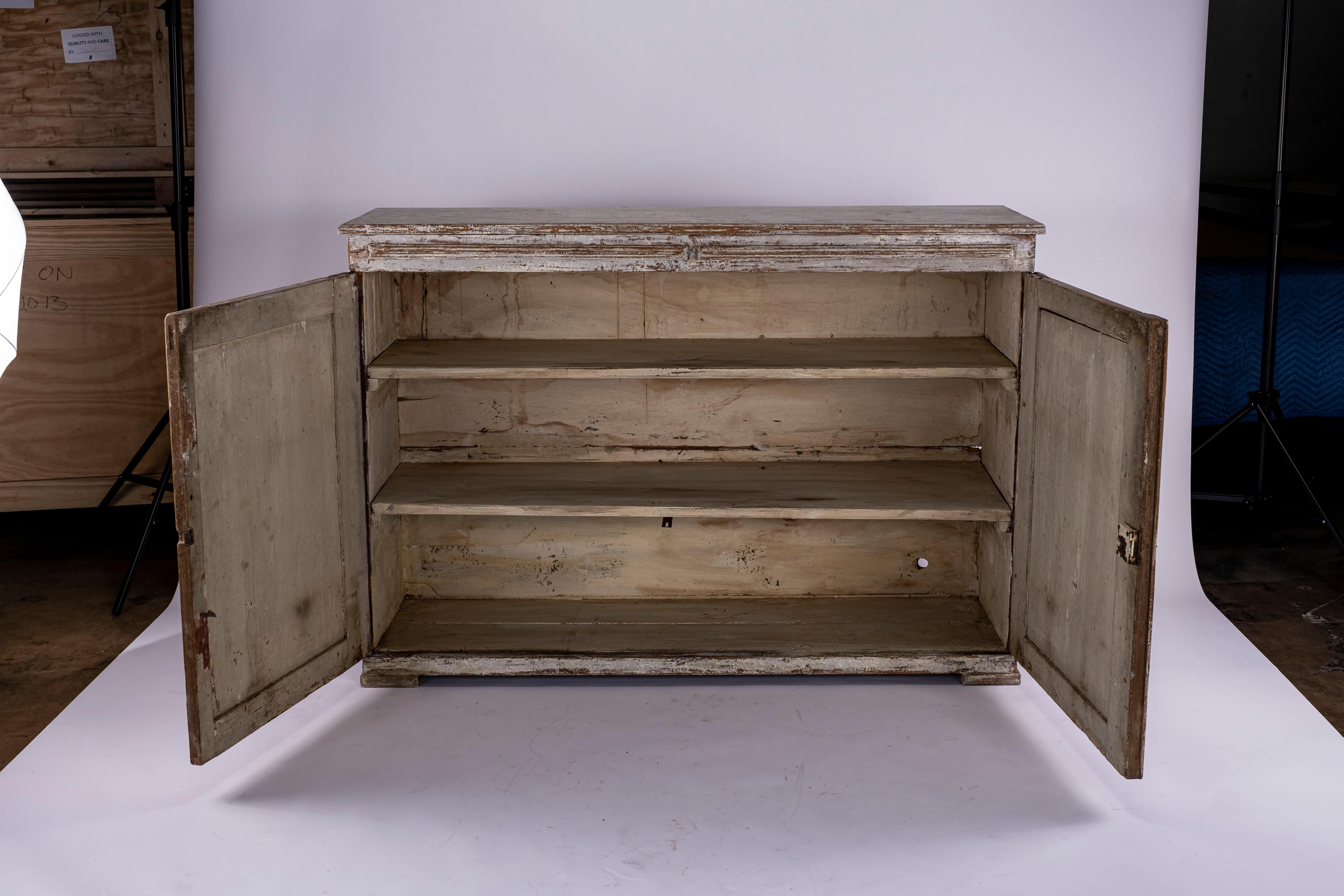 18th century Gustavian buffet with original paint on block feet. Beautiful reeded detail on each door. Each door with a pullout shelves above.