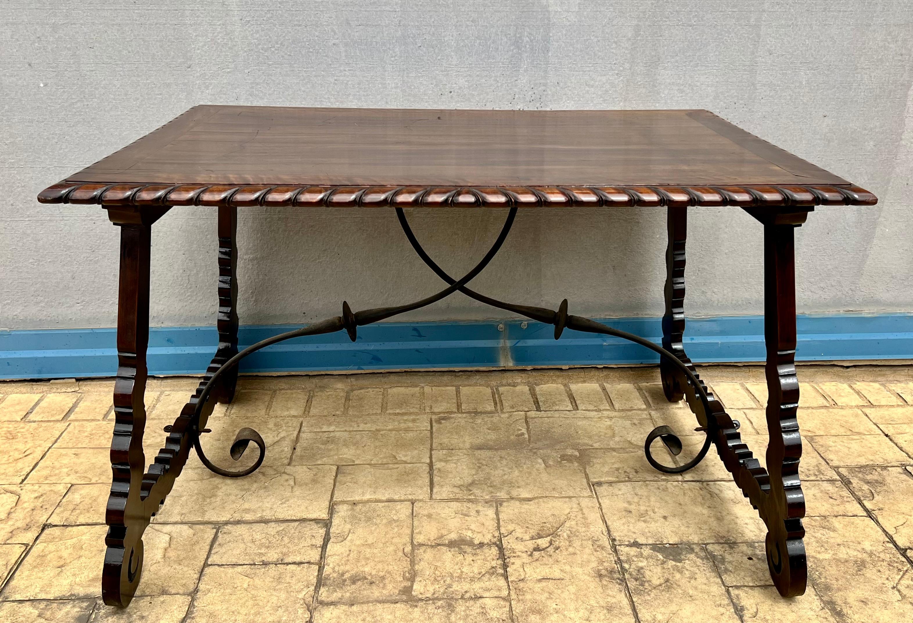 18th century Catalonian dining table with Baroque style lyre legs.

This Spanish 18th century table features a rectangular top over an exquisite trestle type base with lyre shaped legs raised on carved volutes. Big thickness of the plateau and