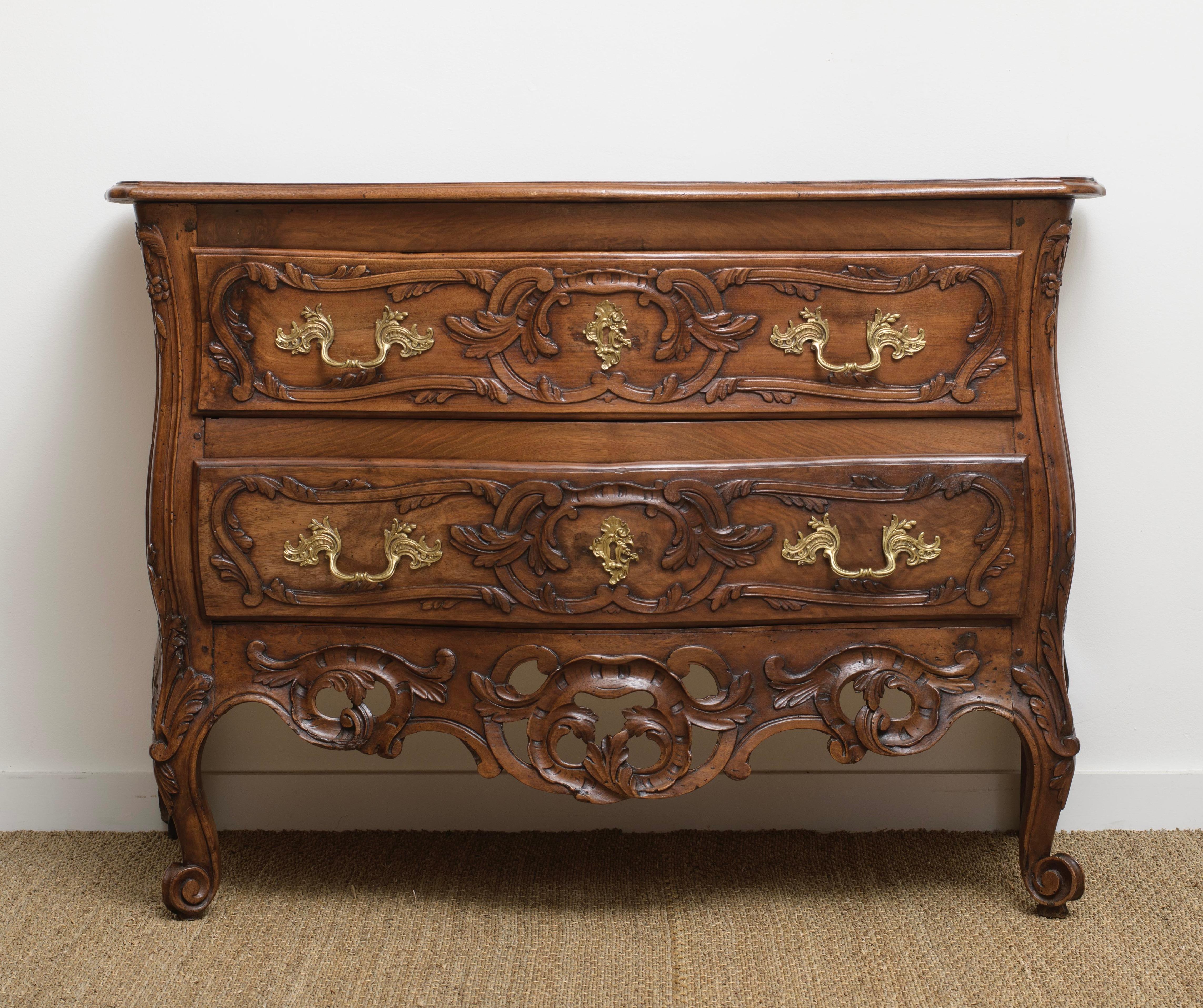 From Nîmes this opulently adorned two-drawer galbe front and openwork crosspiece commode crafted from walnut from Nimes, France, dating back to around 1730.  Commode Sauteuses from Nimes are distinguished by their elongated legs and two drawers.  