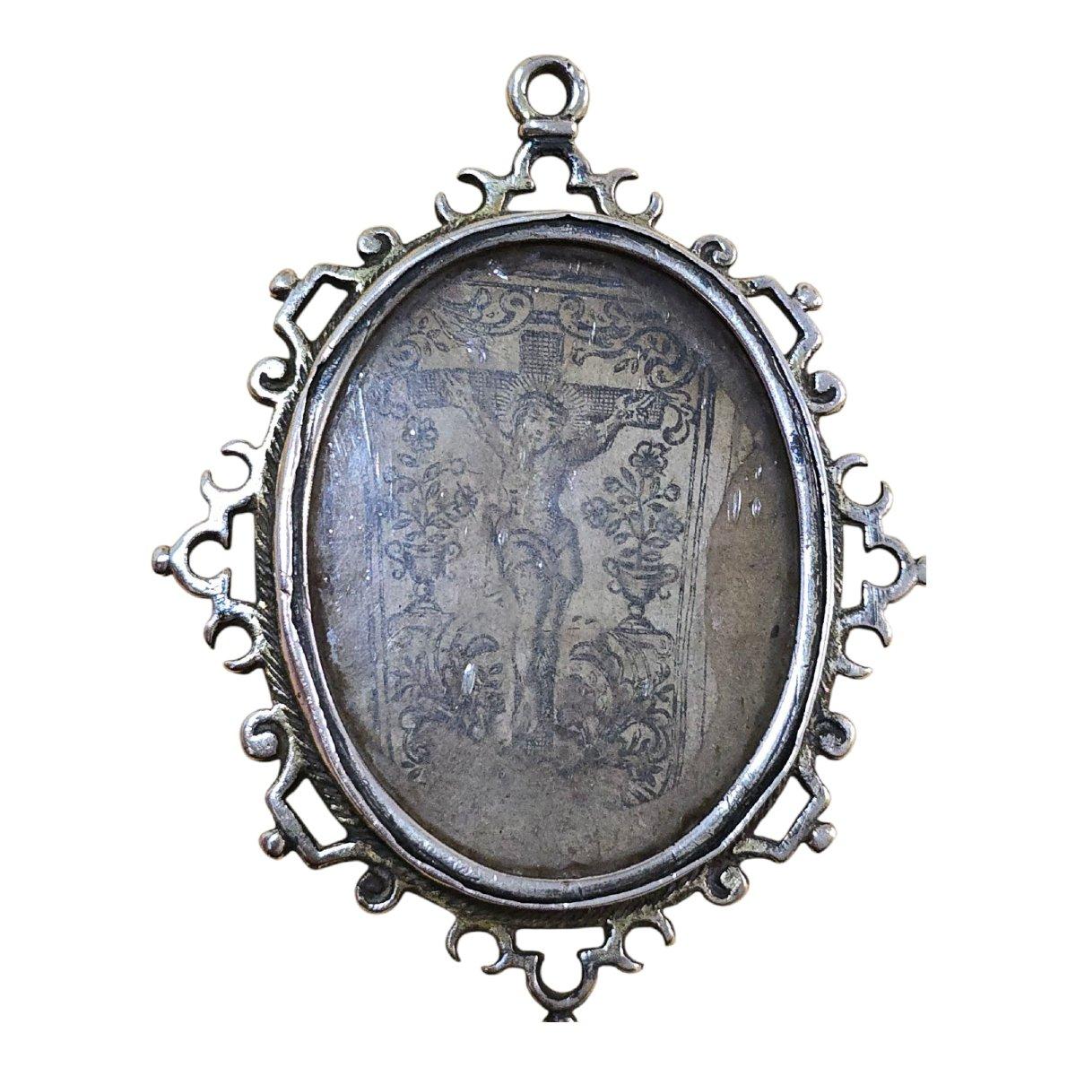 Élégant reliquaire du XVIIIe siècle en argent massif, finement gravé à la main, avec une décoration ornementale typique de l'art religieux baroque. Sa forme ovale présente des détails floraux et symboliques qui reflètent la dévotion et le travail
