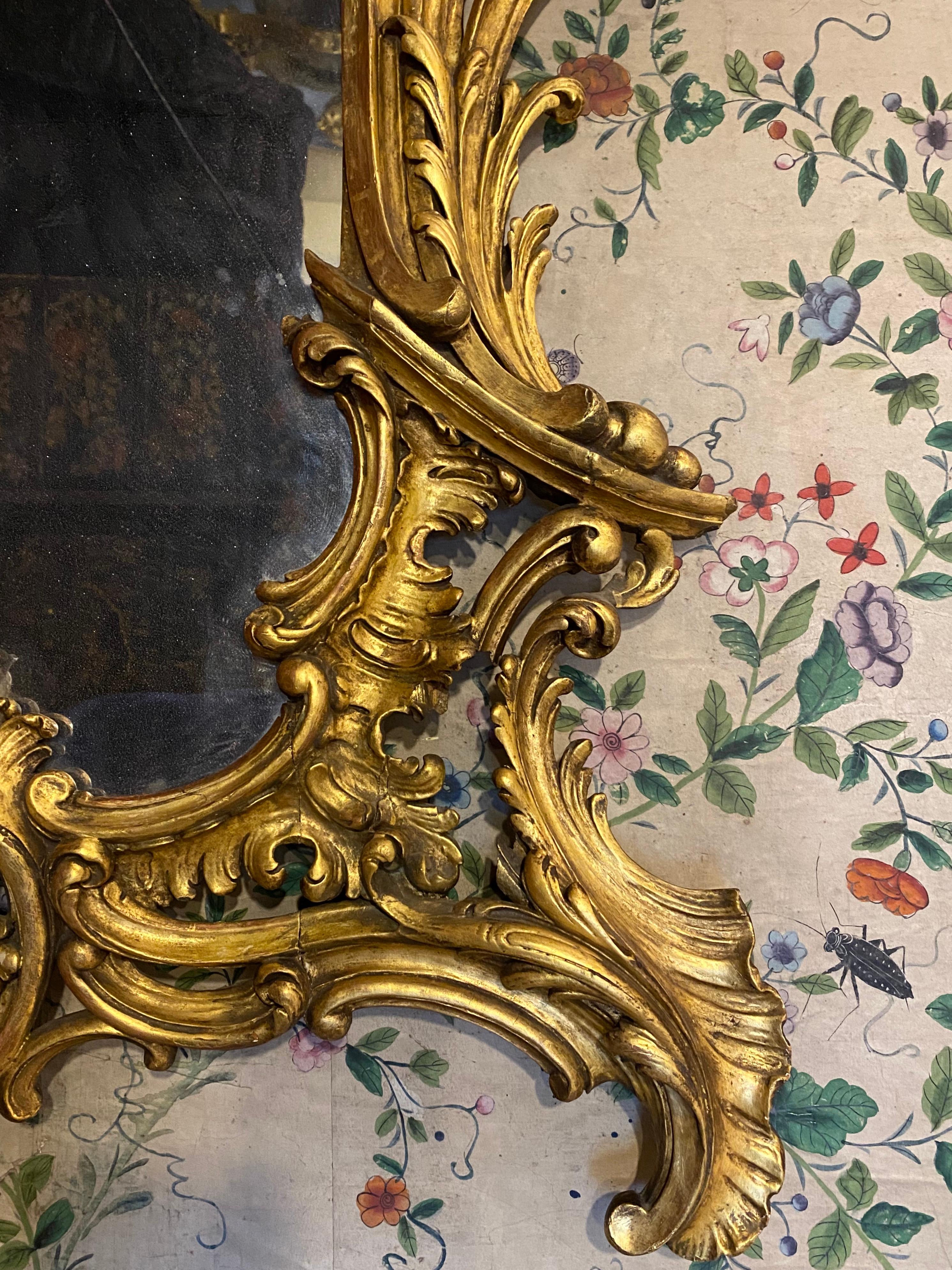 A large scale 18th century Rococo carved giltwood mirror. Circa 1740.

This very impressive, late-Baroque period mirror exhibits many of the features of the early- to mid-18th century, when asymmetry and the craze for the extravagant Rococo reached