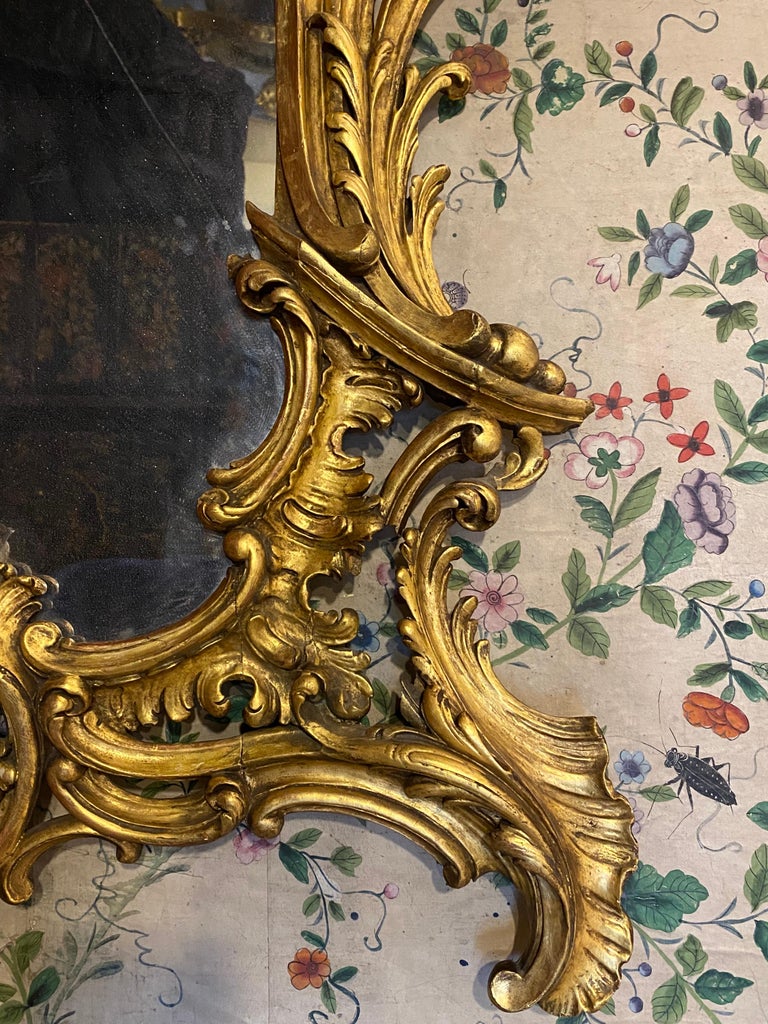 An 18th century Rococo carved giltwood mirror. Circa 1740.

This impressive large-scale late-baroque period mirror exhibits many of the features of the early- to mid-18th century, when asymmetry and the craze for the extravagant Rococo reached its
