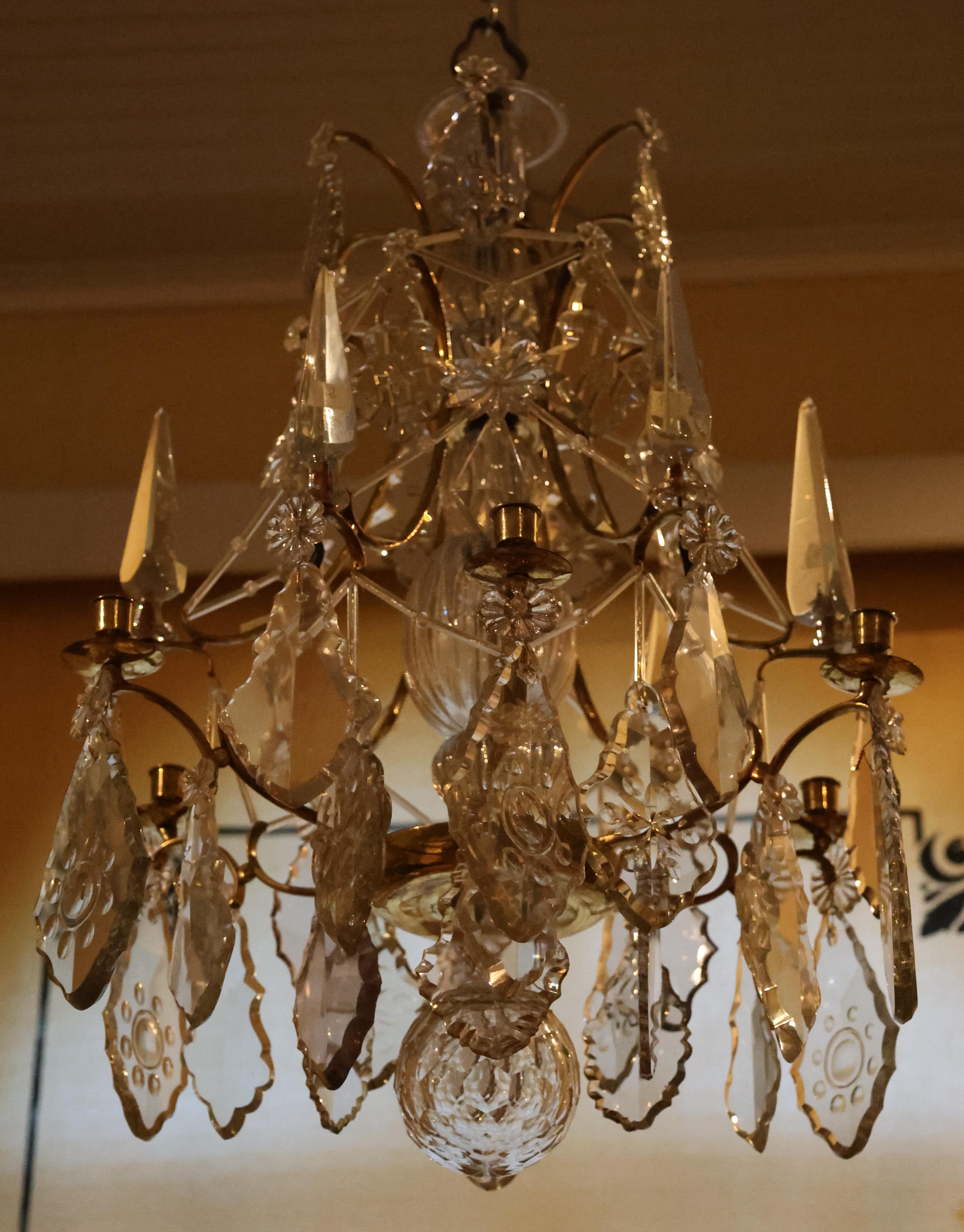 Lustre rococo de grande qualité fabriqué à Stockholm dans les années 1760. Le cadre est en laiton et en bronze doré bruni. Le lustre est soutenu par une tige avec une tige en verre. L'ensemble du lustre est orné de prismes de feuilles coupées. Il