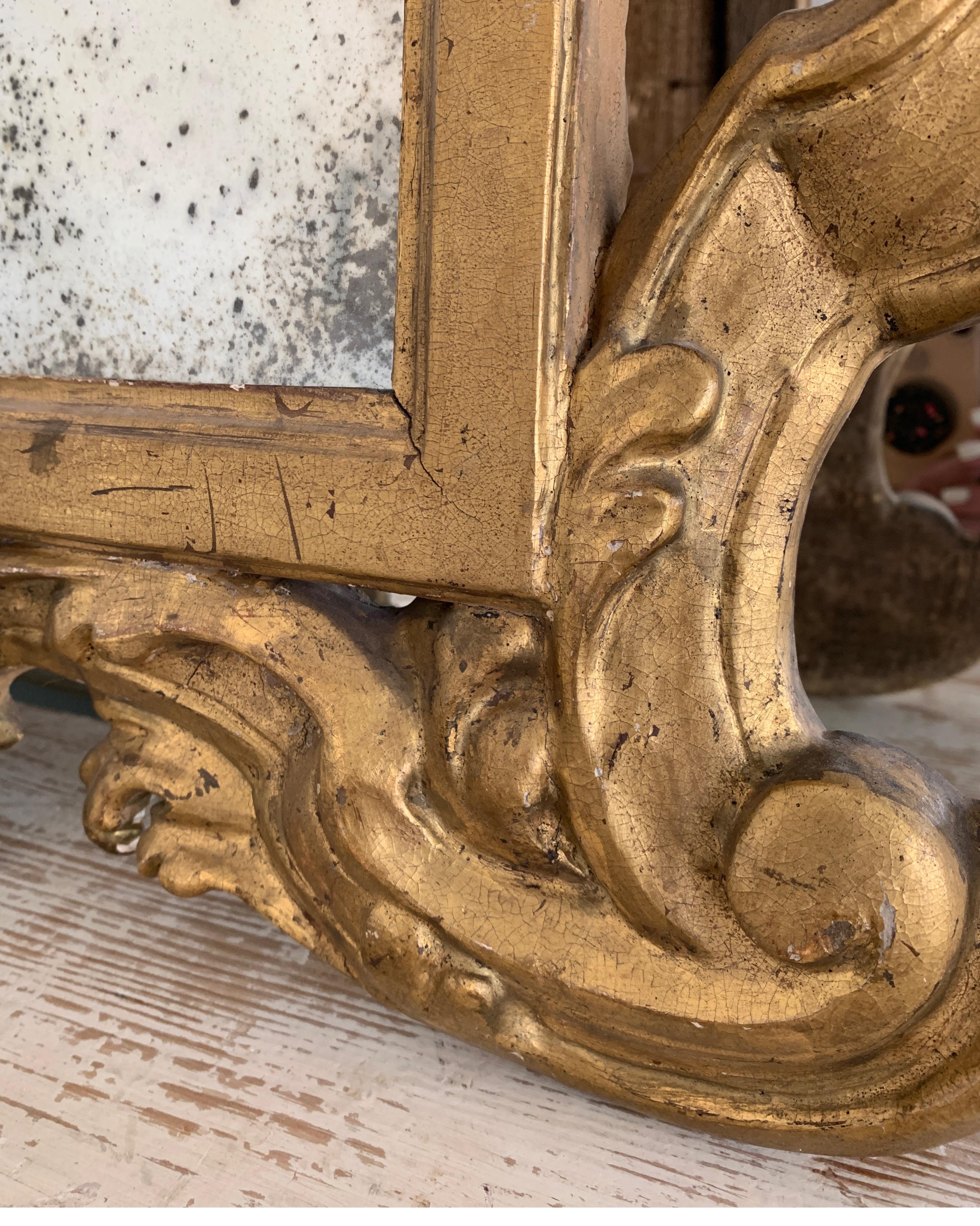 Incredible, rare, small size Rococo gold gilt pair of carved wood mirrors. These are so much more impressive in person. The original gold gilt is amazing as it the old glass. They are terrific over demi-tables, or chests.