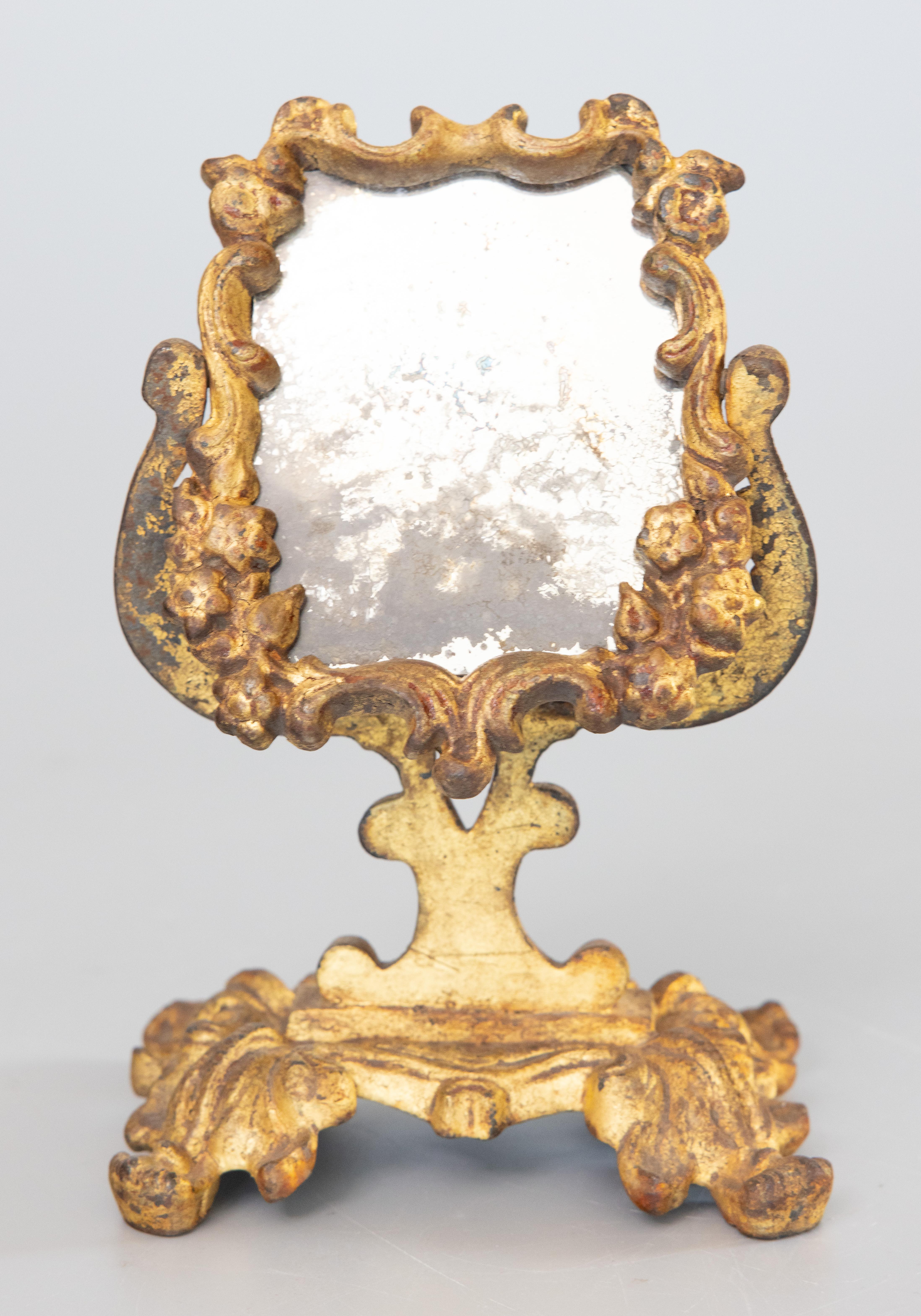 A wonderfully patinated gilt bronze Rococo petite table mirror, with original mercury glass, heavy craquelure. The perfect decorative piece for a side table or dresser. 