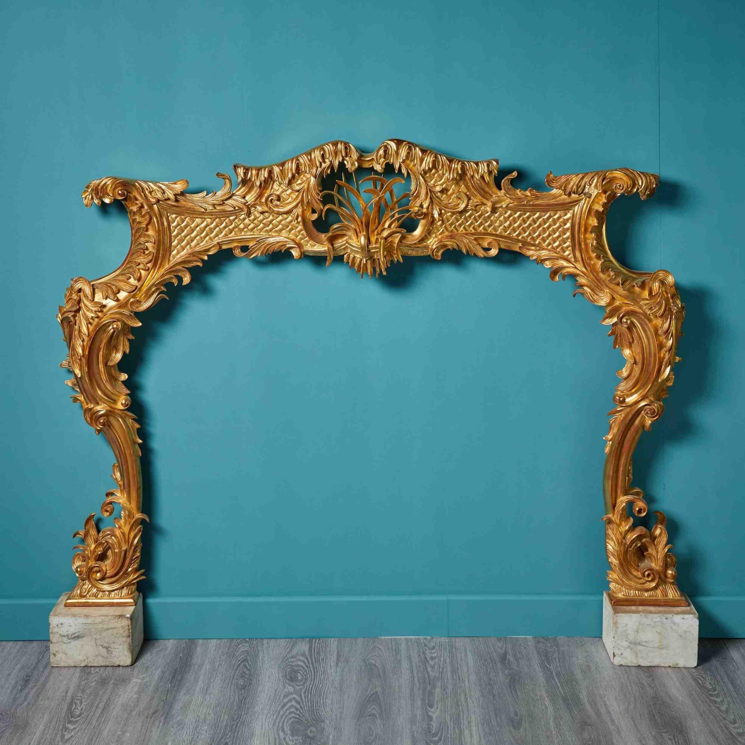 18th Century Rococo Style Giltwood Fireplace. A striking and imposing chimney piece, hand carved and gilded.
 
Additional Dimensions
For an opening height of approx. 117 cm
For an opening width 149 cm
Across the foot blocks 186 cm.