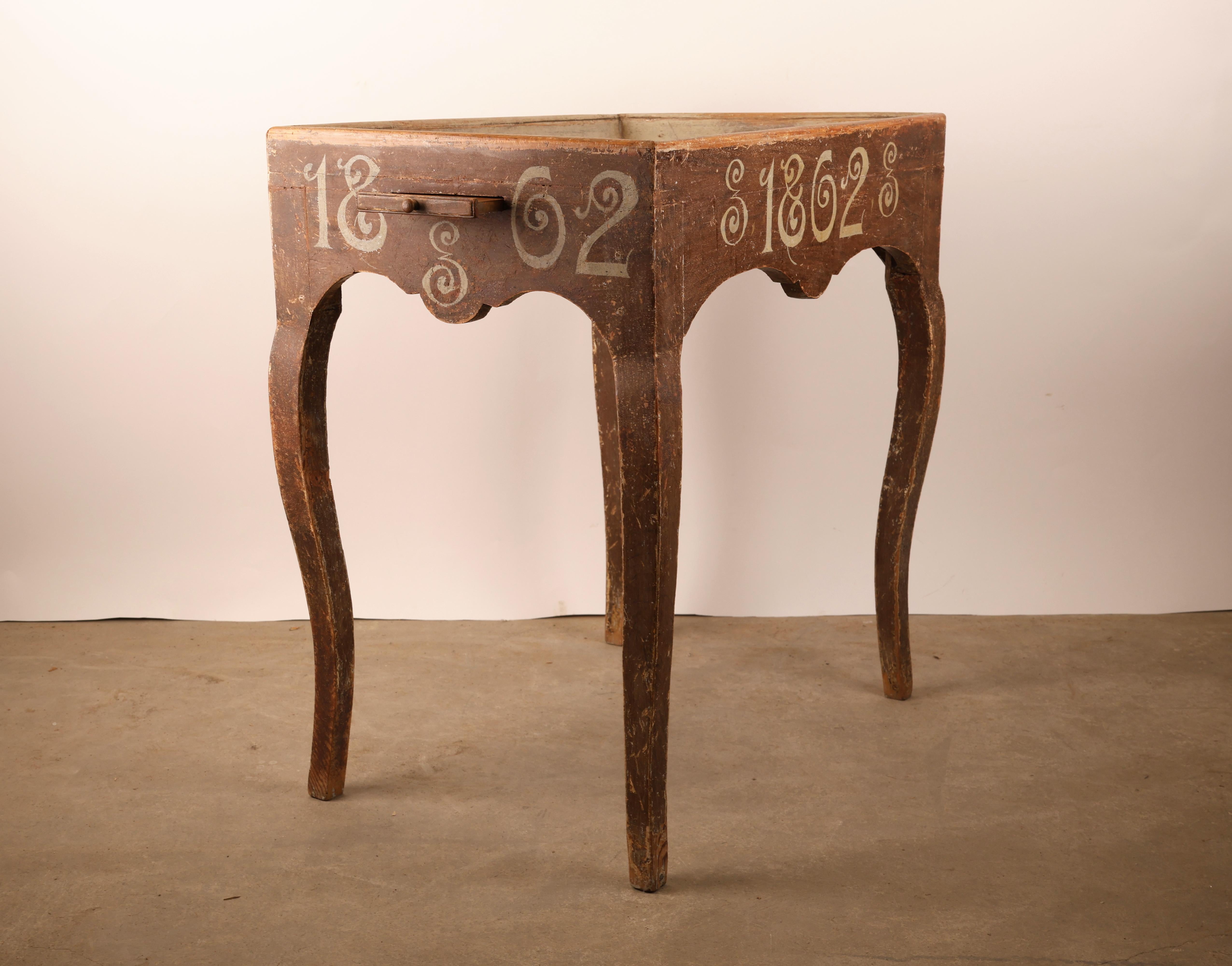 Table à plateau rococo fabriquée à Mälardalen, en Suède, dans les années 1760. La table a été repeinte en 1862. De chaque côté de la table, des surfaces coulissantes sont conçues pour y placer des bougies.