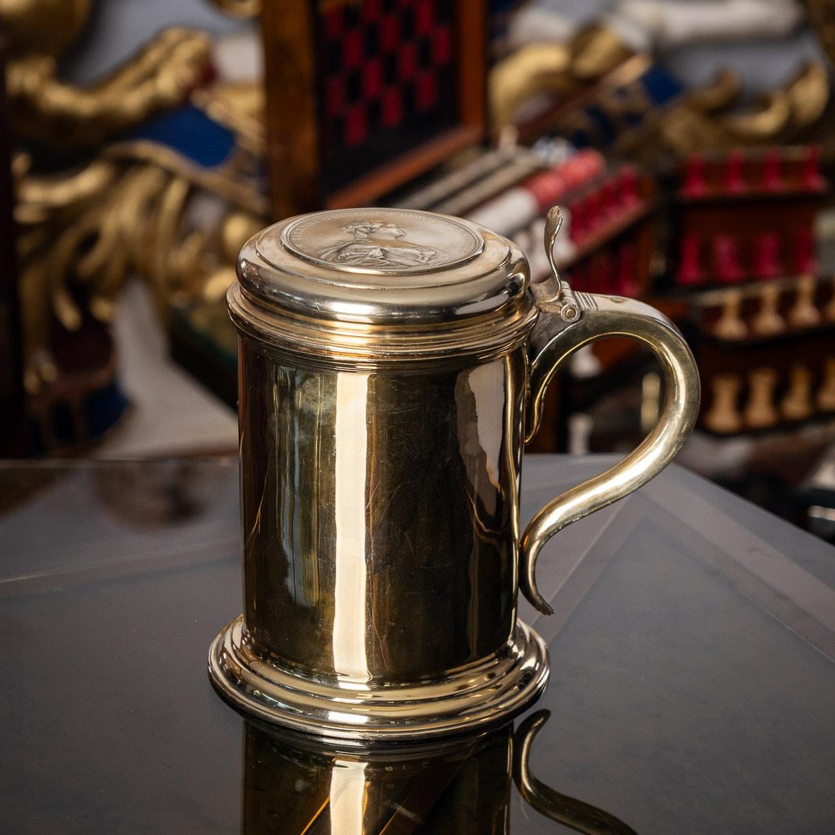 Antique 18th century Imperial Russian solid silver-gilt impressive lidded tankard, parcel gilt, of traditional tapering form on a spreading foot, the sides chased with gilt putto masks and trailing foliage and scrolls on textured silver ground,