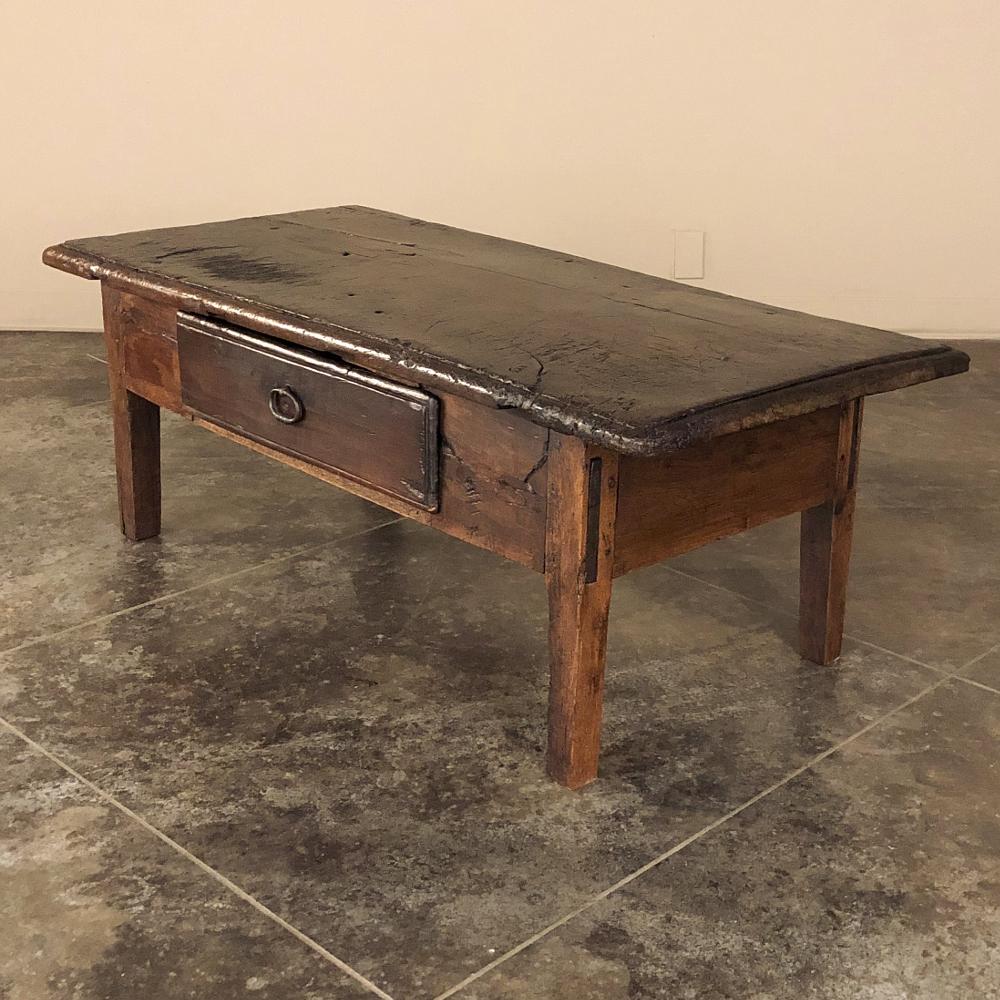 18th century Rustic Country French coffee table was fashioned by able rural artisans from old-growth fruitwood, and features a single board plank top upheld by a framework that was assembled with only four legs and four apron sections, all solid
