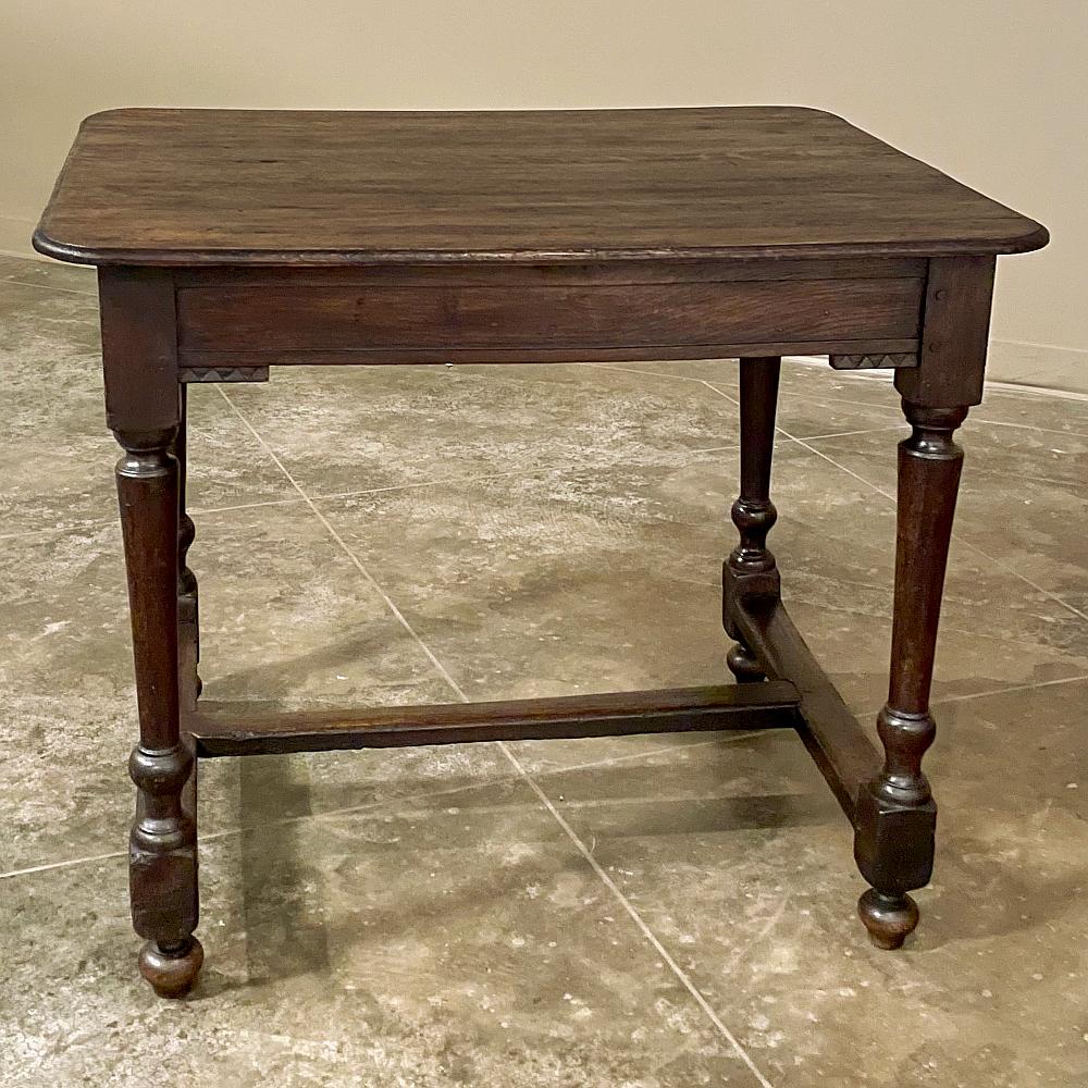 18th Century rustic French end table was fashioned from old growth oak to last for centuries! Plank top has been given a beveled edge with rounded corners, with an apron supporting underneath embellished with subtle accents next to the four turned