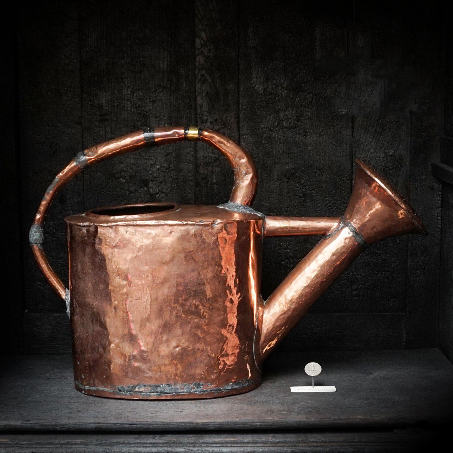 A large and heavy 18th century copper garden watering can.

Hand-beaten or hammered copper can with a non-detachable pouring spout. 
The copper rolled handles show some great 'repairs' which gives this watering can a nice patina.

This would look