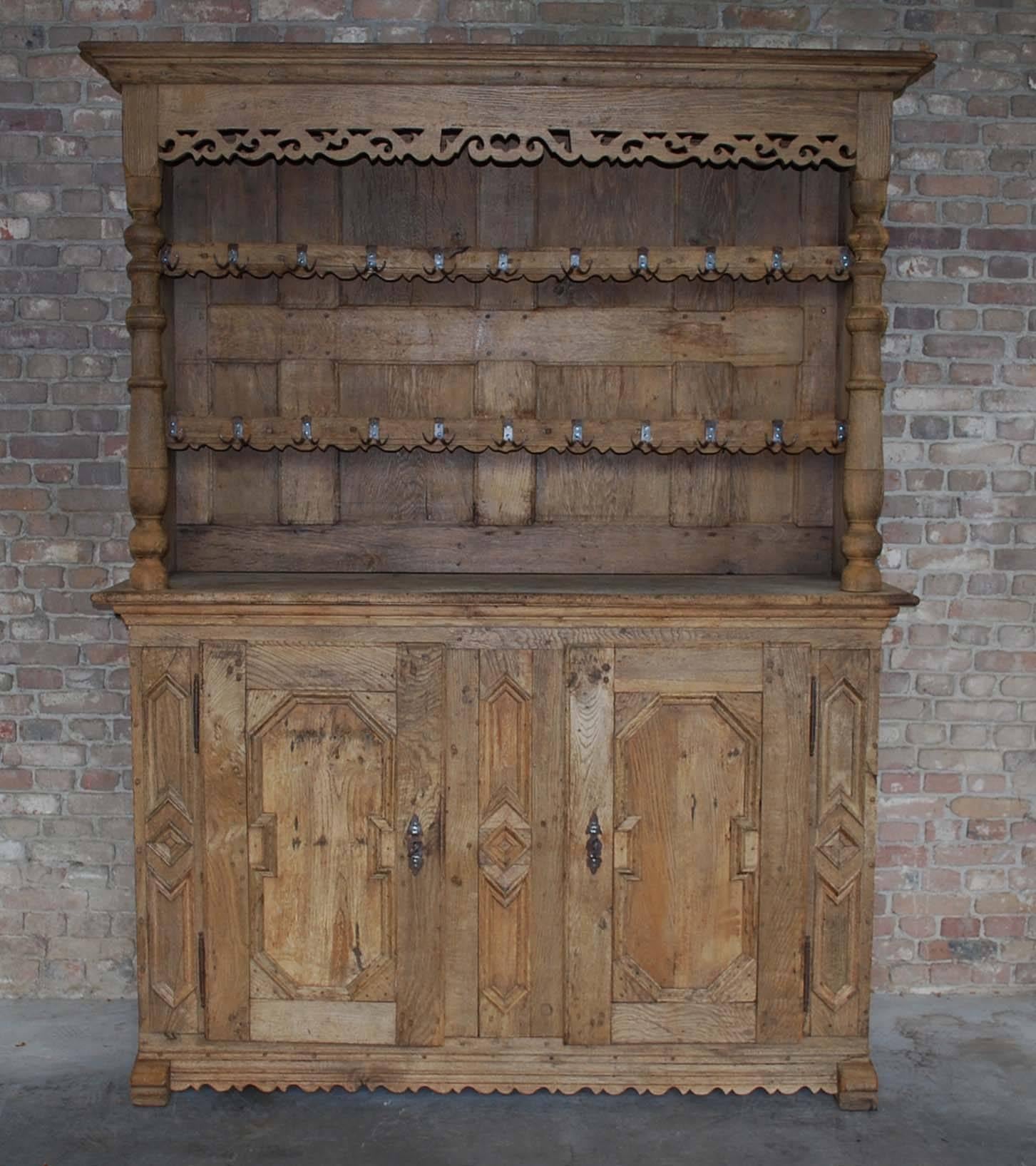 A beautiful German farmhouse kitchen cabinet. The lower cabinet has two doors with elaborate mouldings. The lower left cabinet has two fixed shelves, the lower right cabinet has one fixed shelf.
The upper cabinet is equipped with manu hand-forged