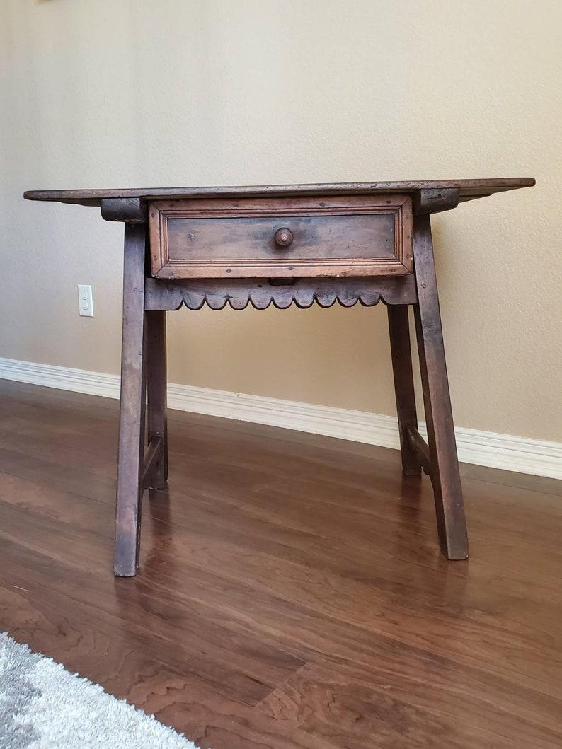 Patina perfection! The charm of this rustically elegant antique Spanish Colonial Baroque Period work table is in the hand-crafted details, primitive early inlay, and dark rich warm patina of the heavily distressed walnut top. 

Born in the 18th