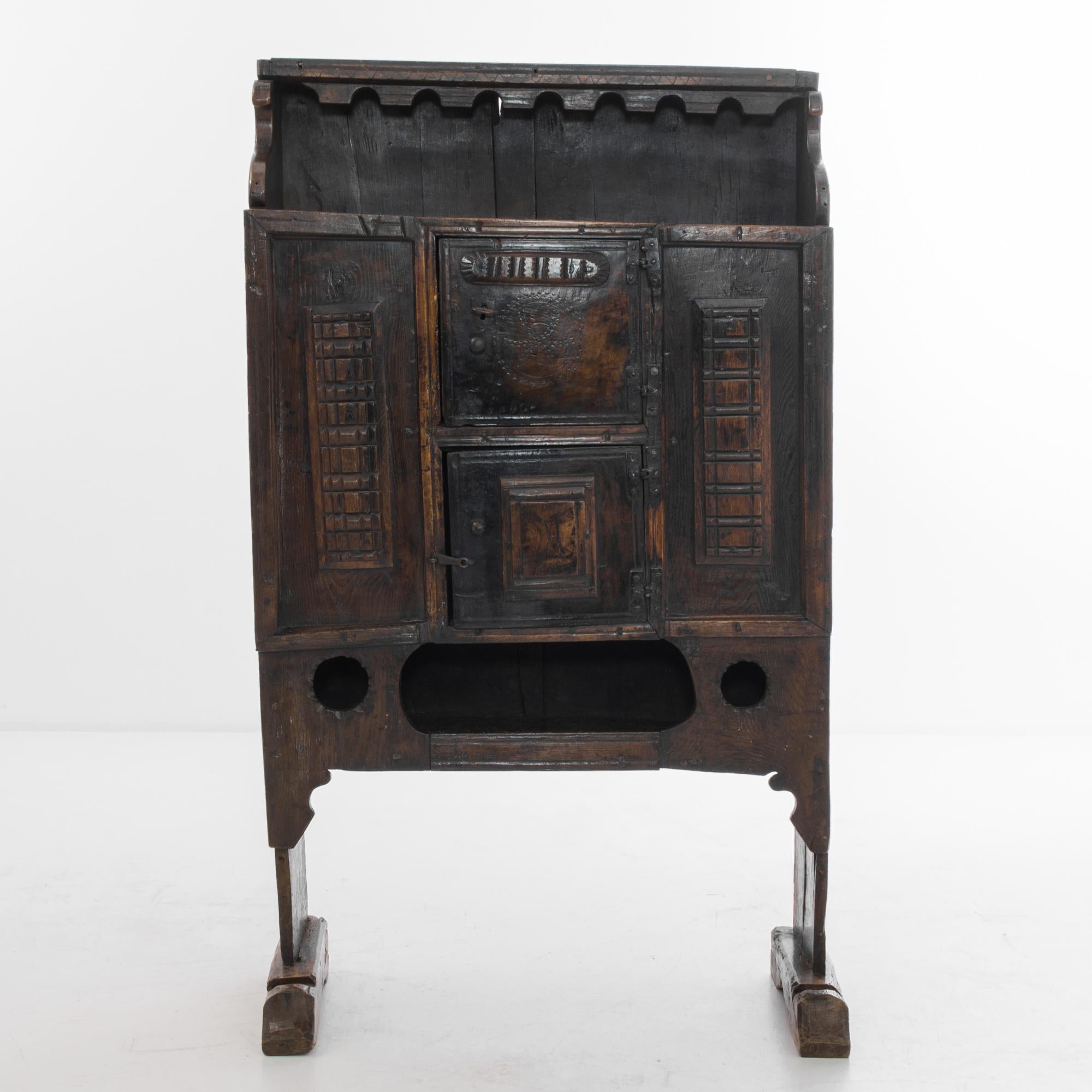 This wooden cabinet was made in Spain, circa 1700, and displays a deep, glossy sheen from the original patina, toned and polished by time. An exceptional find, the cabinet impresses with its handcrafted detail and rich ornamentation, from the