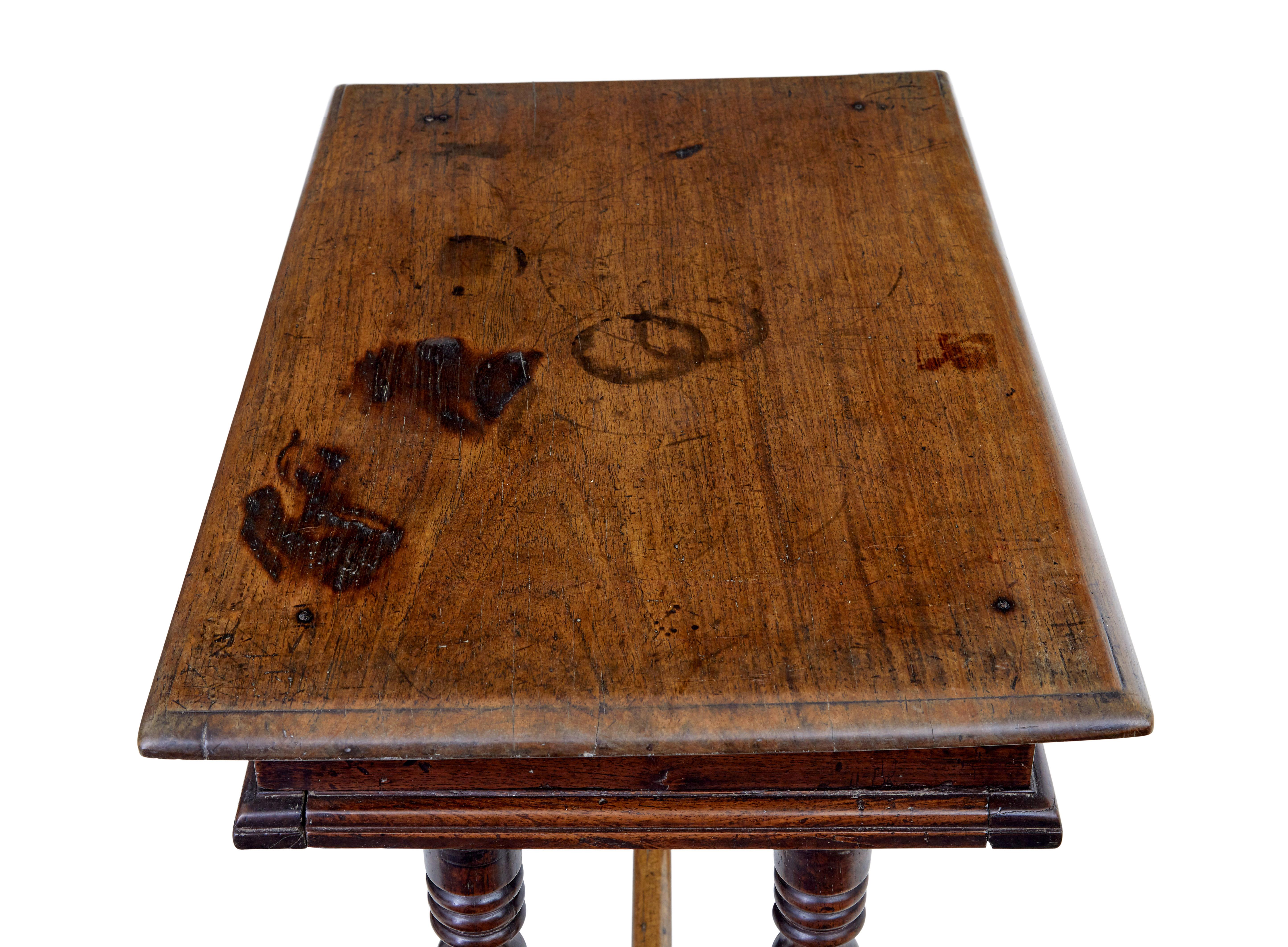 Quirky rustic walnut side table circa 1780.

Over-sailing top beneath which is a single drawer with 2 turned handles.

Standing on 4 turned legs and sledge feet, united by stretcher.

Lock missing to drawer, surface burns and staining to top, which